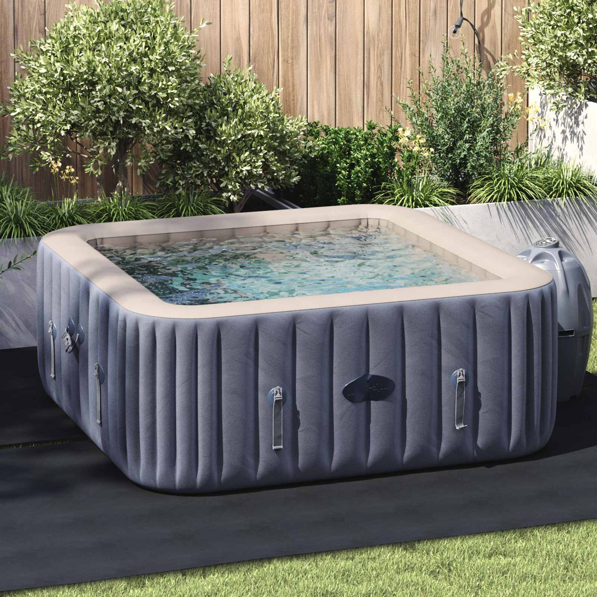 Aufblasbarer Whirlpool im Garten mit Holzverkleidung und üppiger Vegetation.