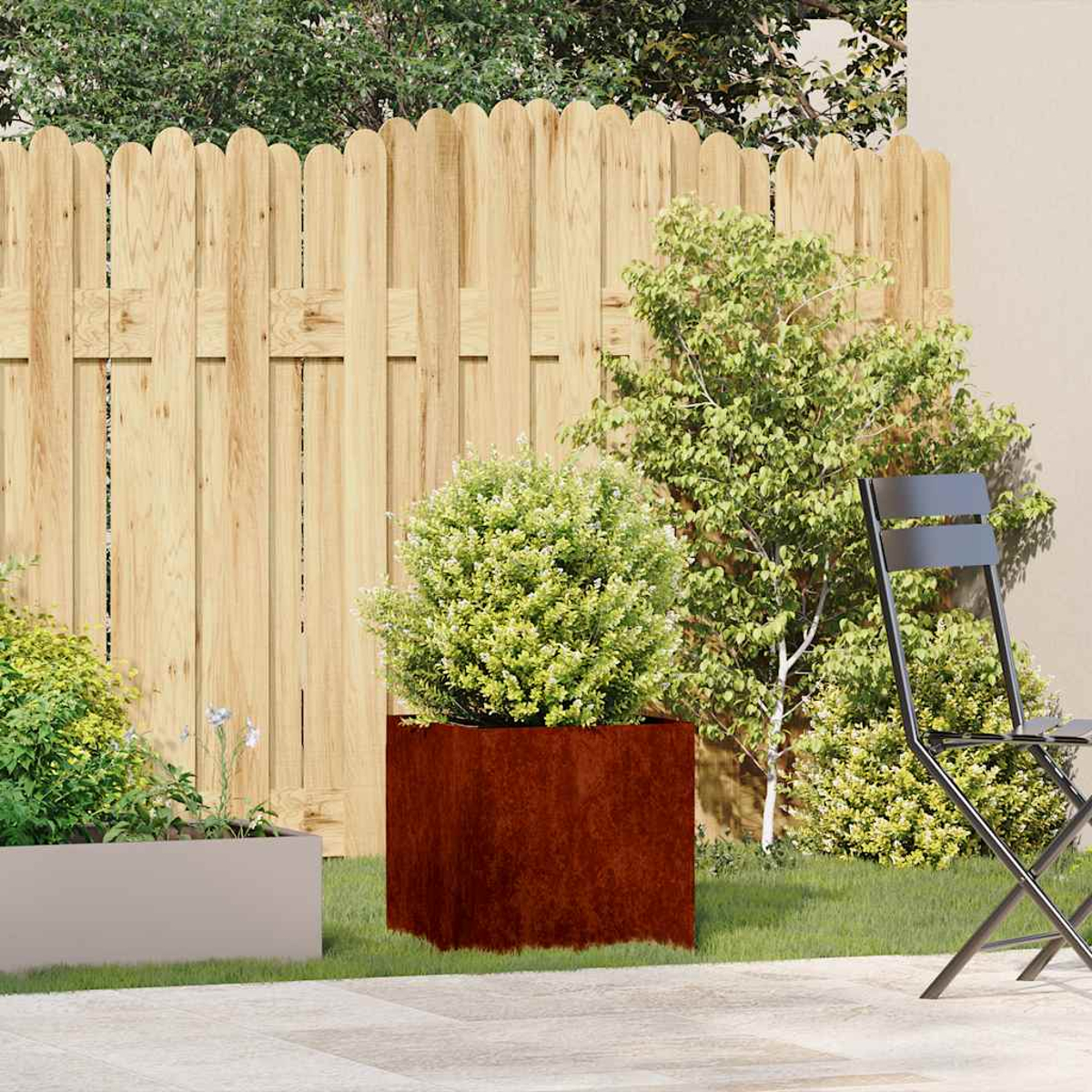 Un piccolo giardino con una recinzione in legno, piante e un tavolo con sedia.