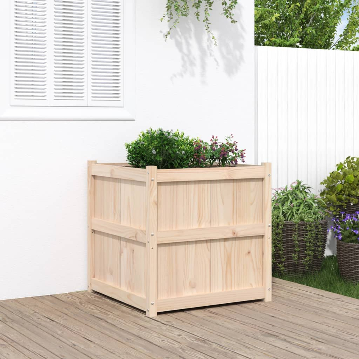 Ein hölzerner Blumenkasten mit grünen Pflanzen und lila Blumen auf einer Holzterrasse.