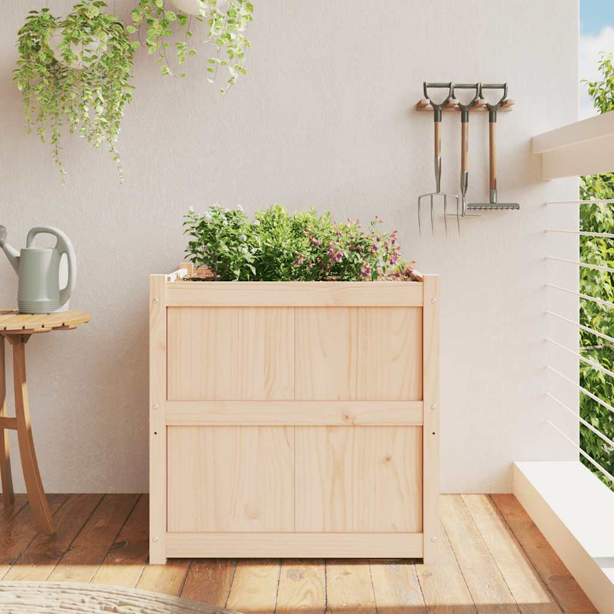 Holz-Hochbeet mit Pflanzen auf einem Balkon mit Werkzeugen.