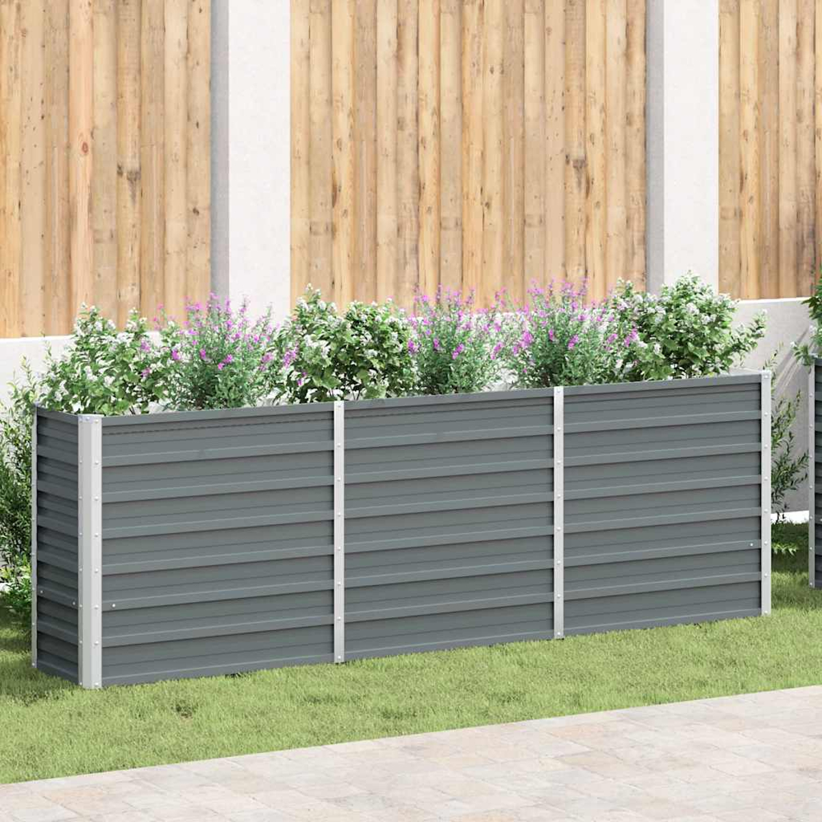 Ein grauer Hochbeet aus Metall mit silbernen Pfosten und Pflanzen mit lila Blumen.