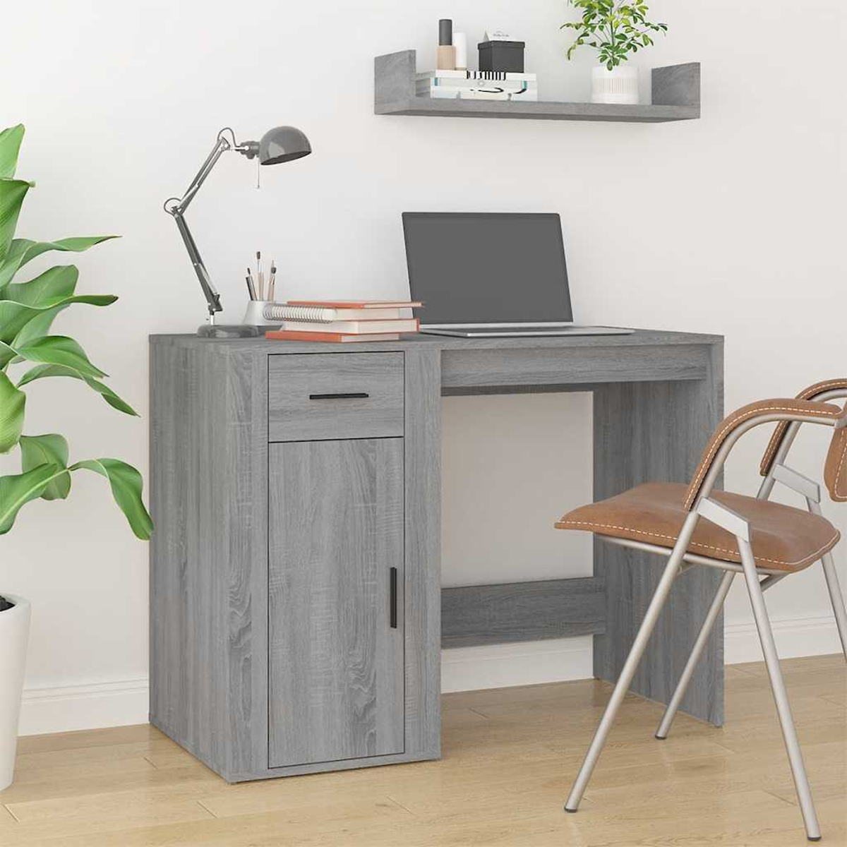 Grauer Schreibtisch mit Laptop, Lampe, Büchern und braunem Stuhl.