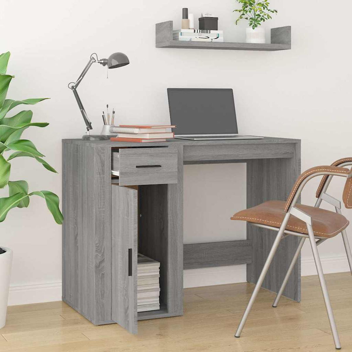 Grauer Schreibtisch mit Laptop, Lampe, Büchern und einem braunen Stuhl.
