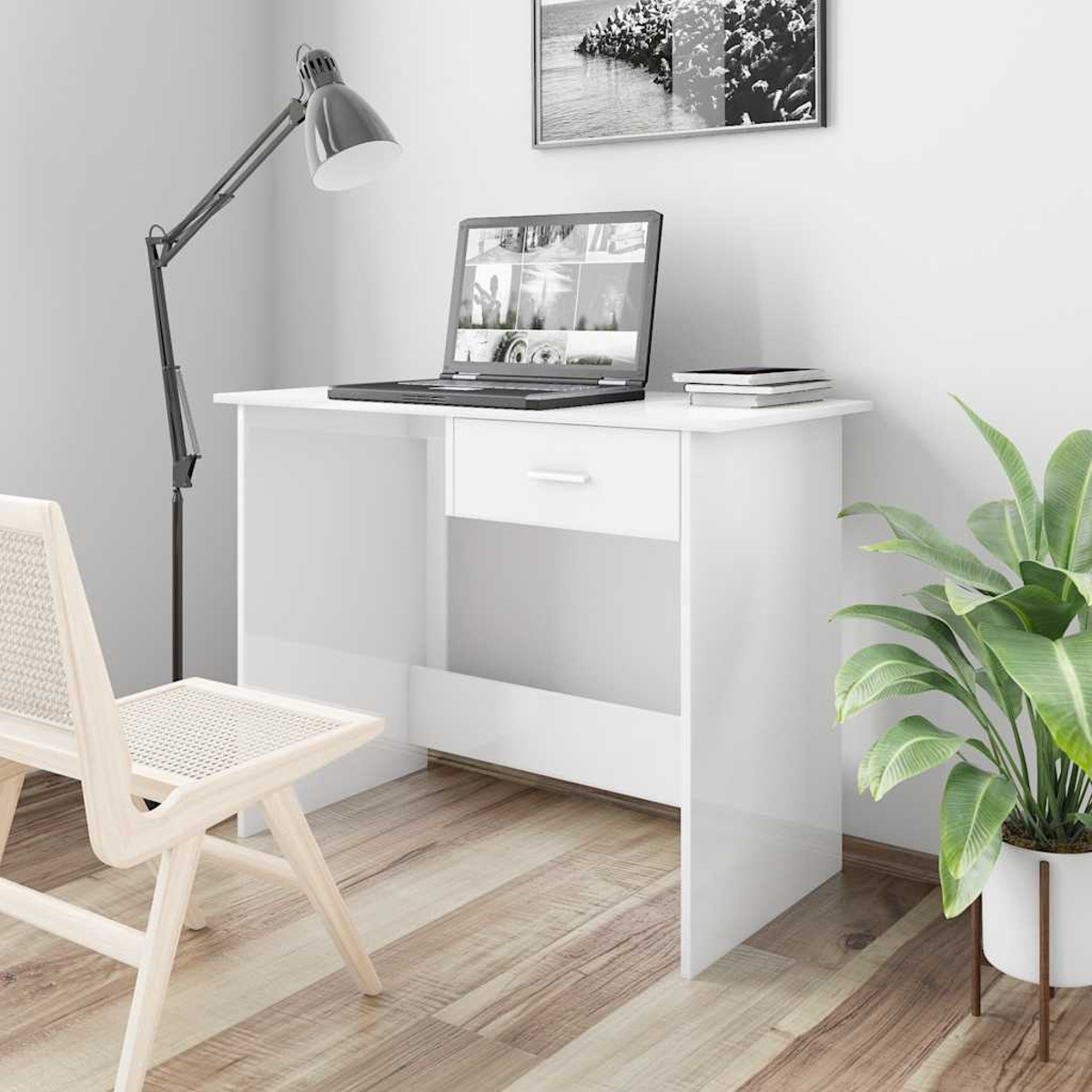 Ein weißer Schreibtisch mit Laptop, Lampe und Stuhl.