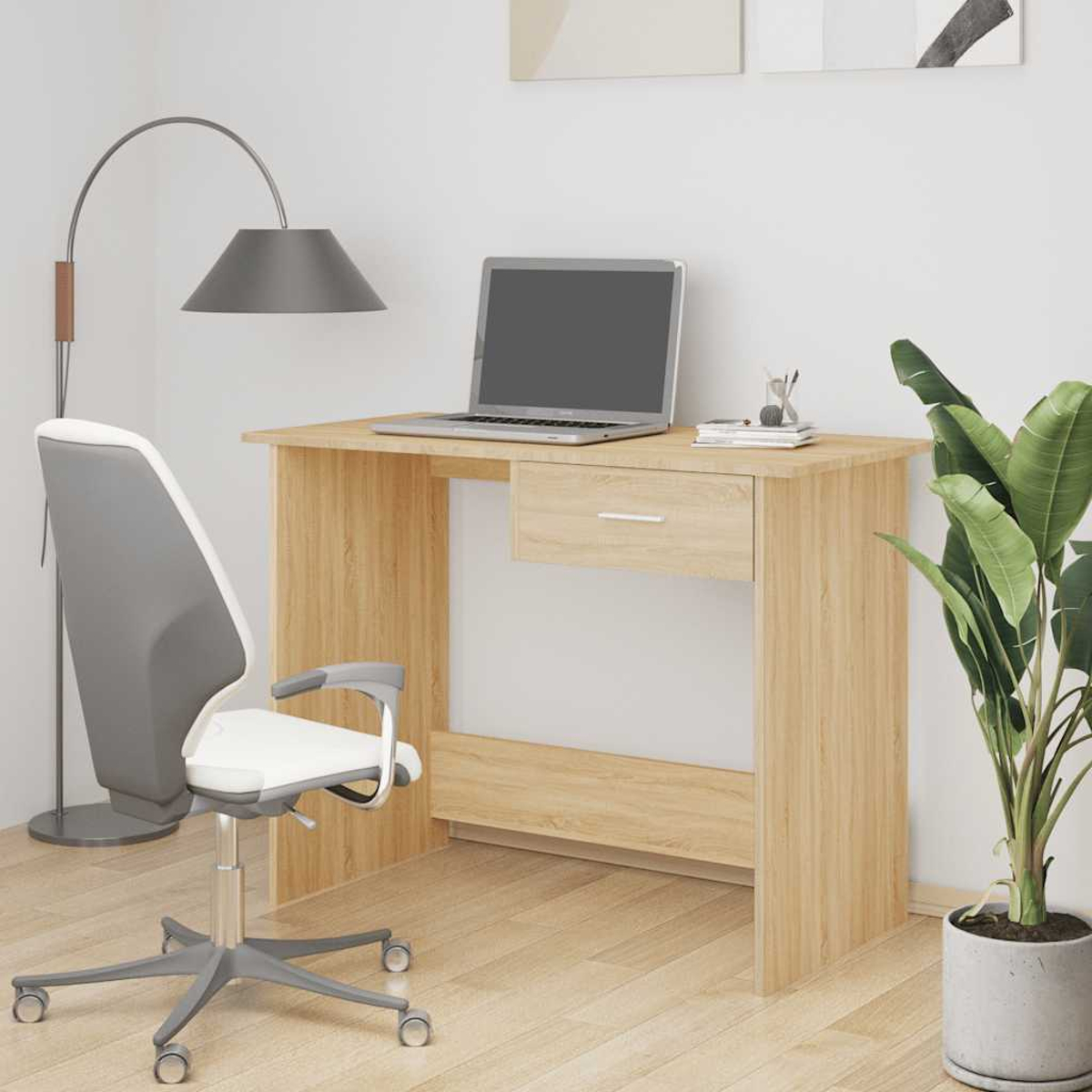 Ein heller Schreibtisch mit Laptop, Stuhl, Lampe und Pflanze.
