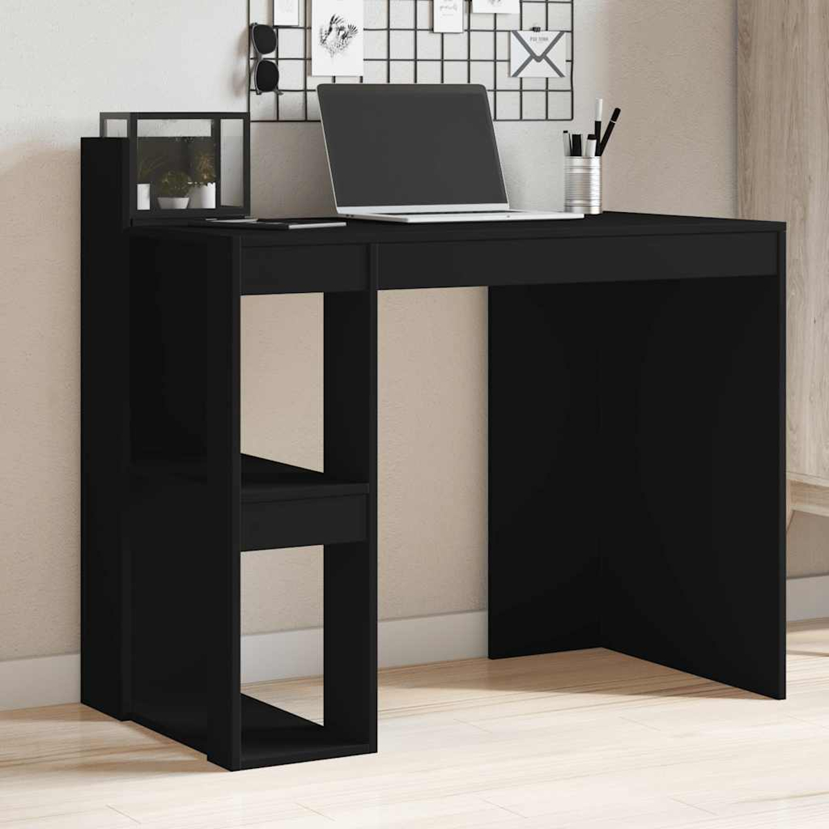 Schwarzer Schreibtisch mit Laptop, Pflanzen und Ablagefläche.