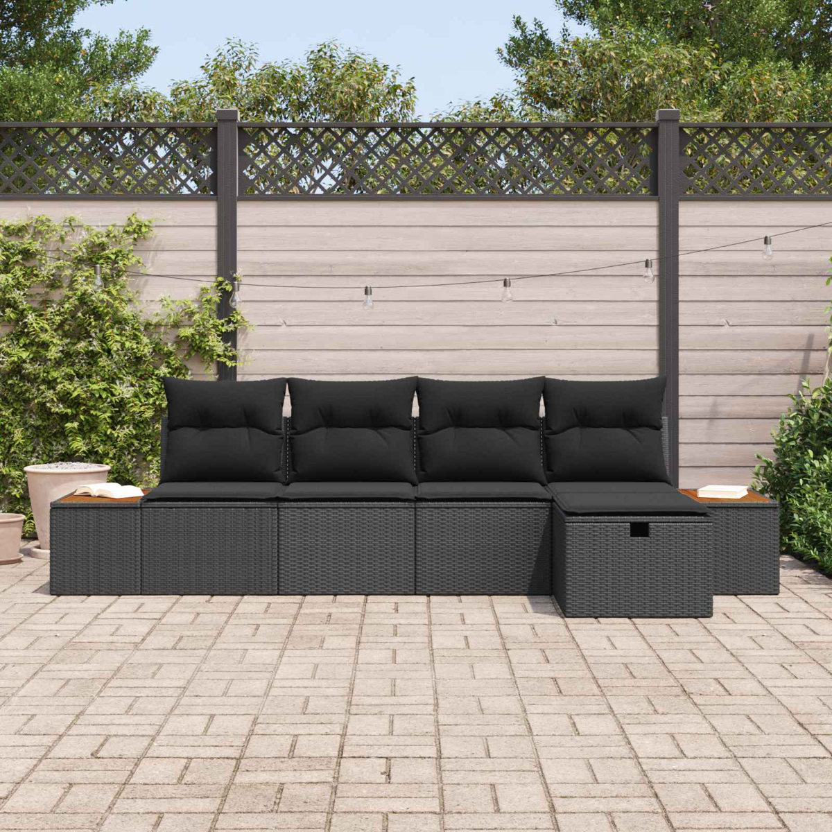 Dunkelgraues Lounge-Set mit schwarzen Kissen auf einer gepflasterten Terrasse.