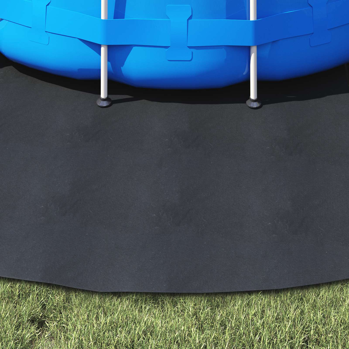 Ein aufblasbarer blauer Pool steht auf einer schwarzen Matte über Gras.