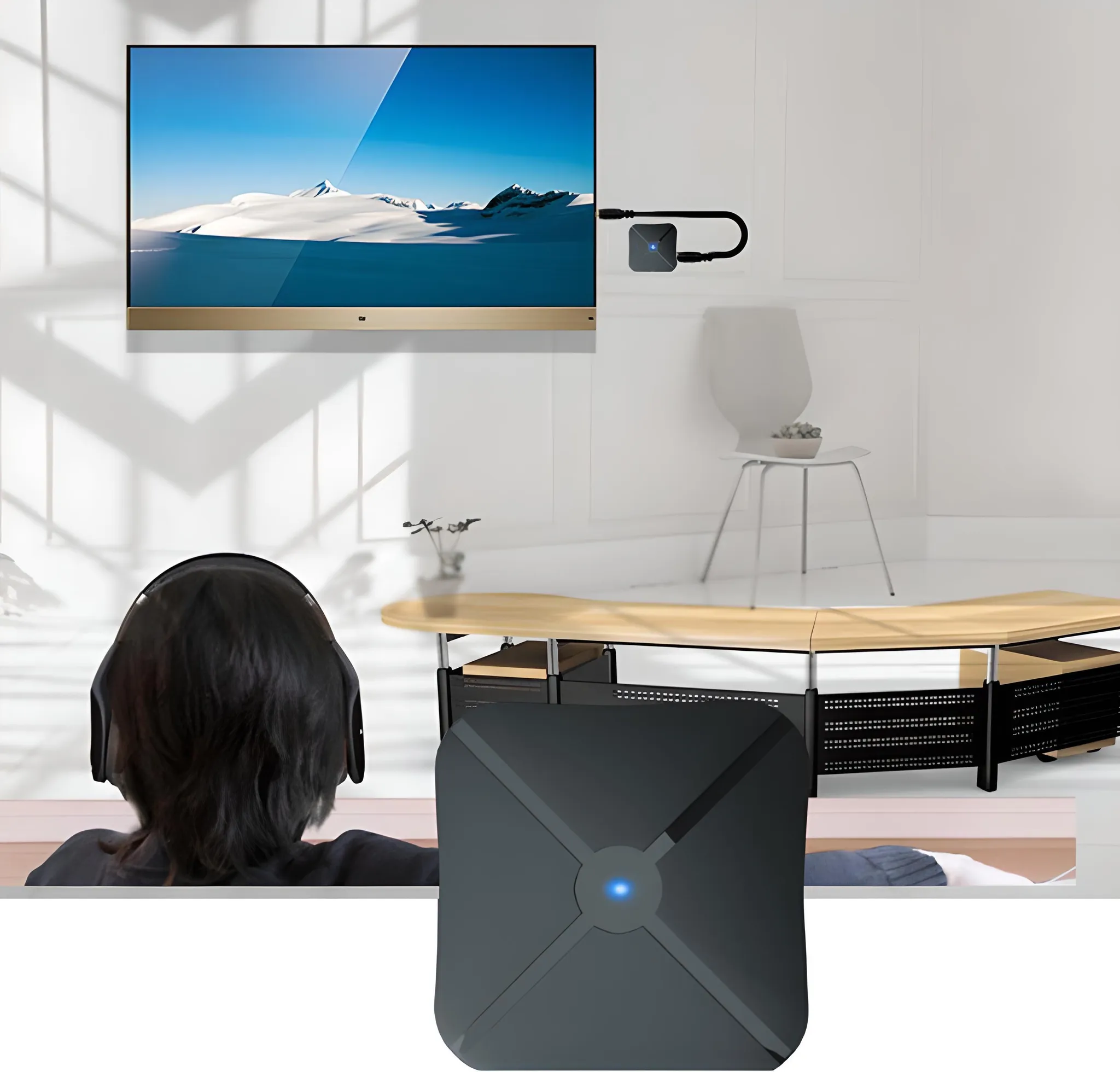 Ein Flachbildfernseher mit Berglandschaft, angeschlossen an ein kleines schwarzes Gerät.