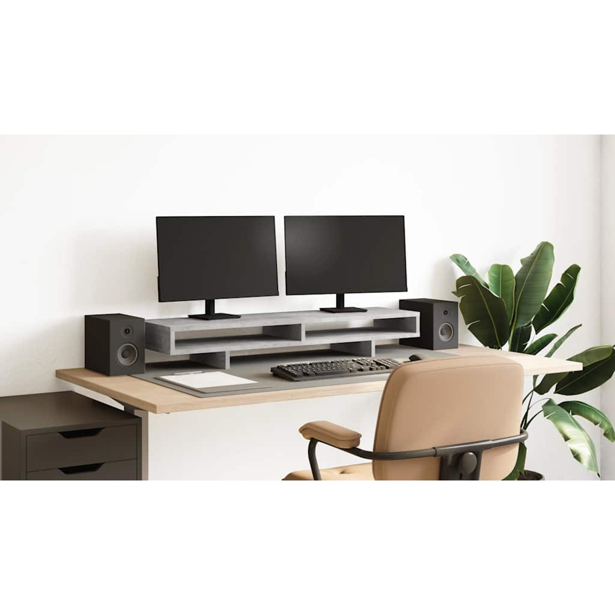 Ein Schreibtisch mit zwei Monitoren, Tastatur, Maus, Lautsprechern und einer Topfpflanze.
