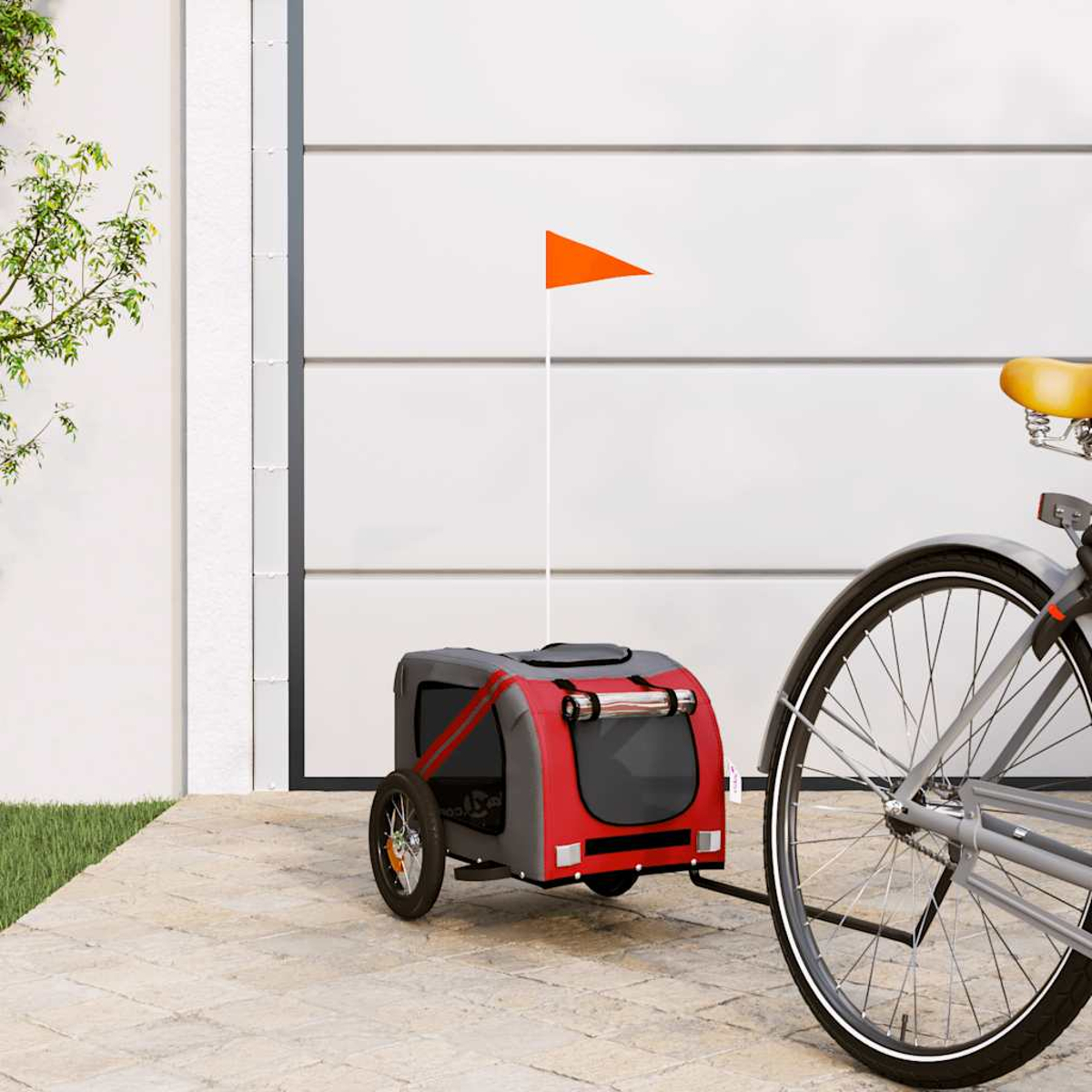 Ein roter und grauer Fahrradanhänger mit orangefarbener Flagge steht neben einem Fahrrad.
