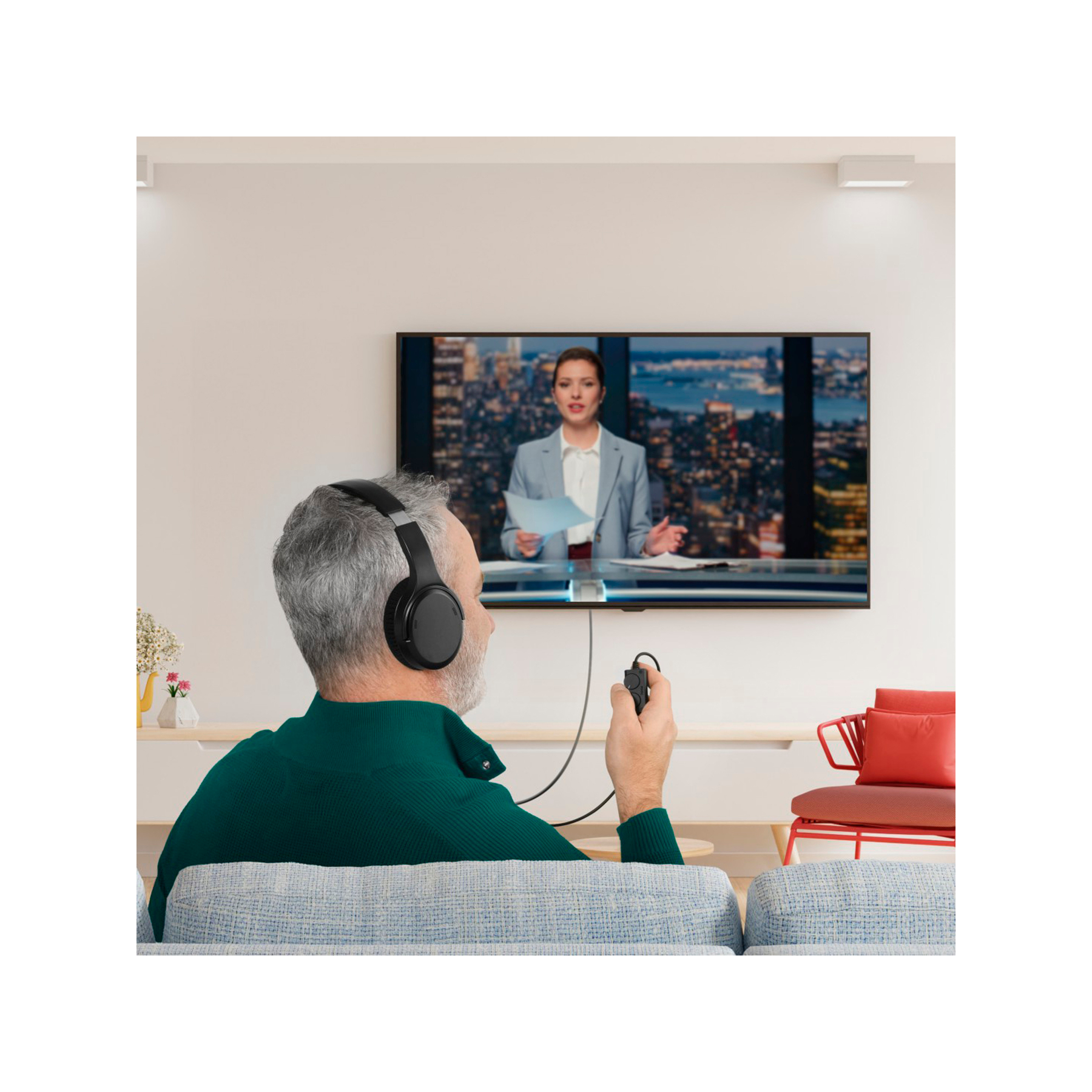 Homme avec casque regarde les infos TV, tenant une télécommande.