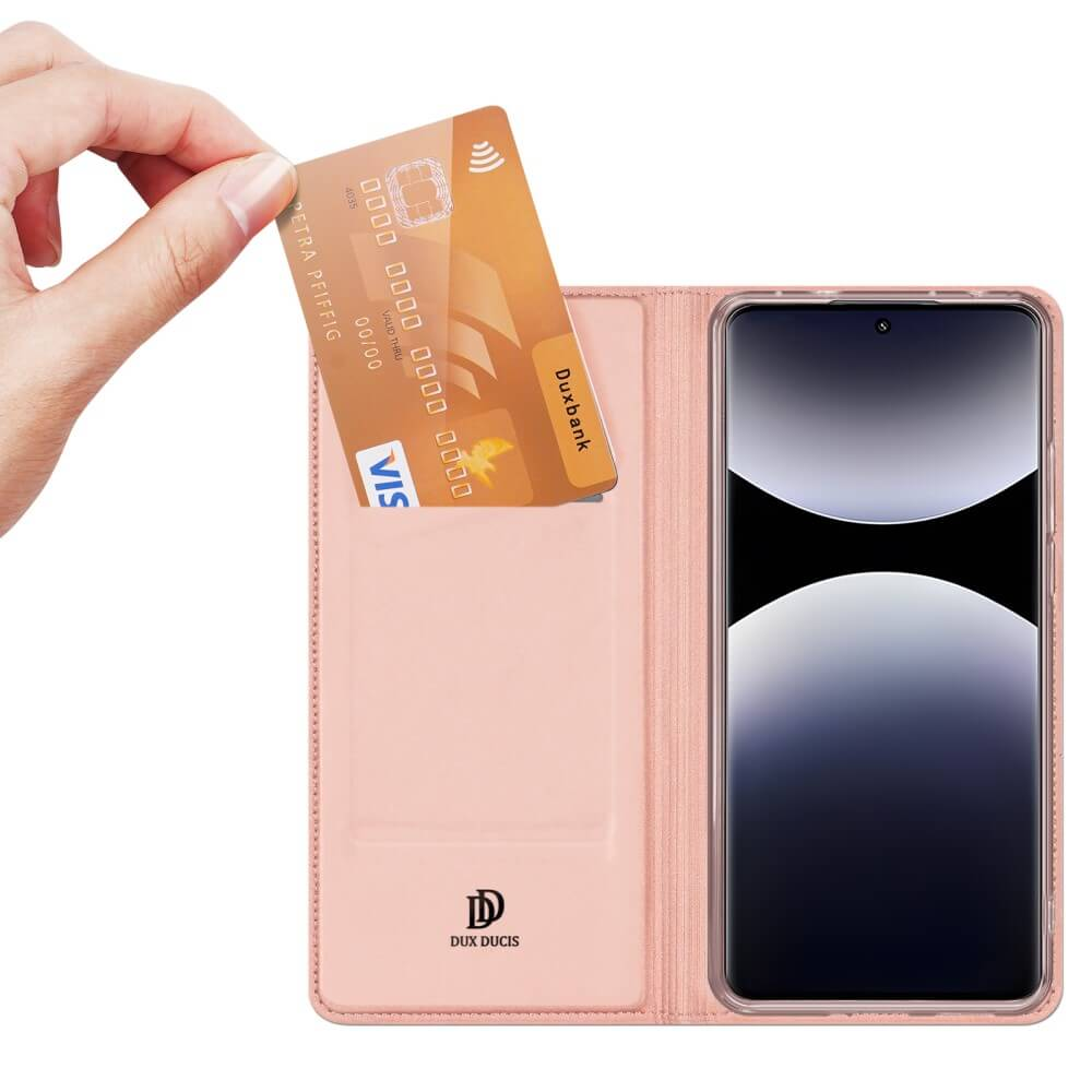 Eine Hand steckt eine goldene Visakarte in eine rosafarbene Hülle neben einem Smartphone.
