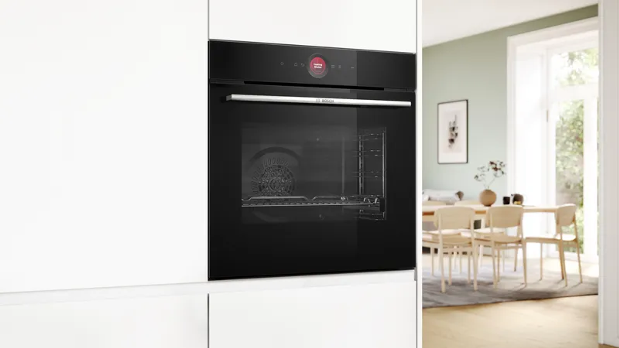 Un horno empotrado negro moderno con asa plateada en una cocina.