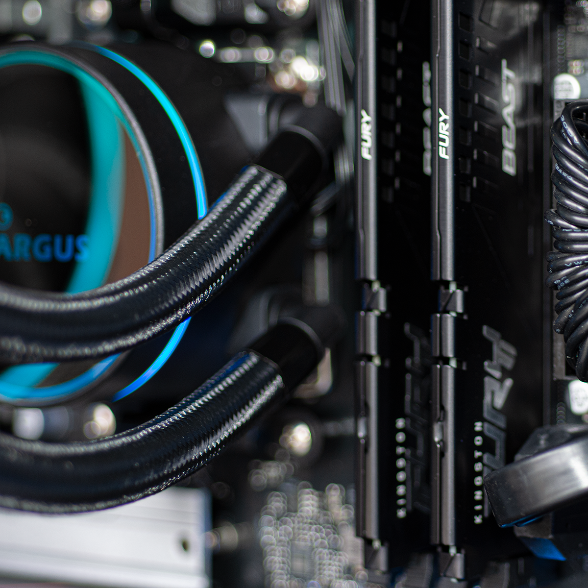 Een computer CPU-koeler met blauwe verlichting en zwarte slangen naast RAM-modules.