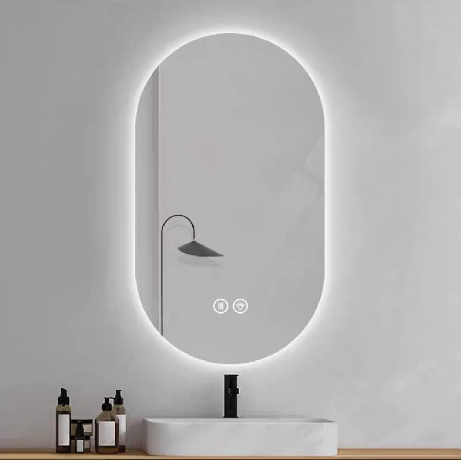 Ein ovaler Spiegel mit LED-Beleuchtung über einem Waschbecken mit Armatur.