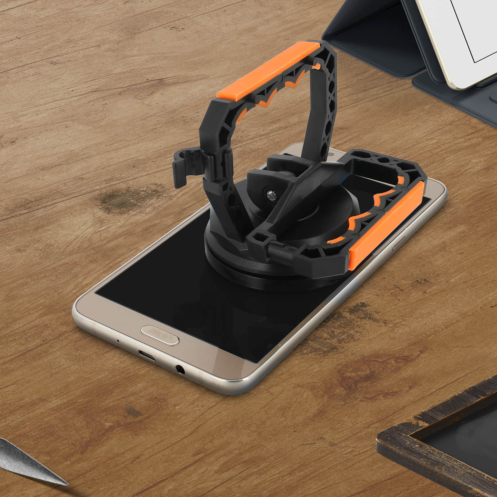 Un supporto nero e arancione su uno smartphone su tavolo in legno.