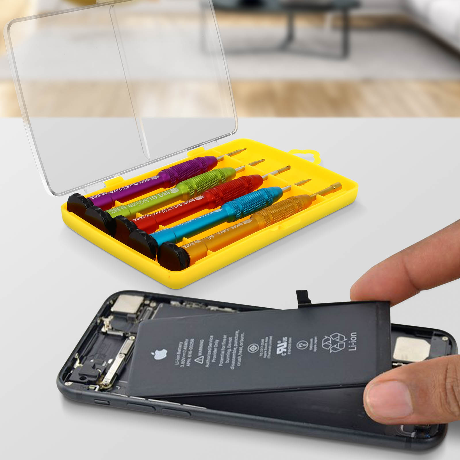 Un set di cacciaviti colorati in una custodia gialla accanto a uno smartphone aperto.