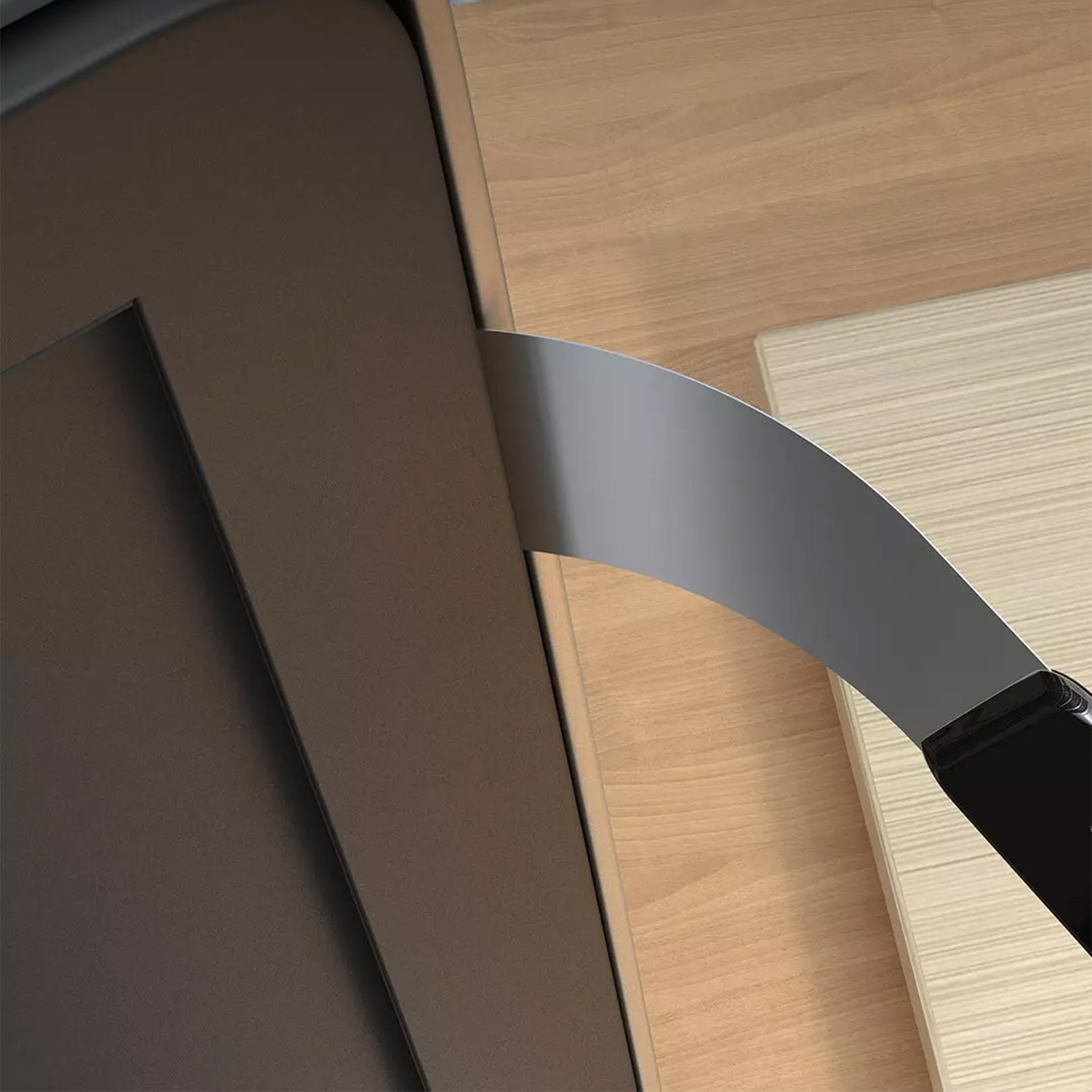 Un coltello d'argento con manico nero su superfici di legno.