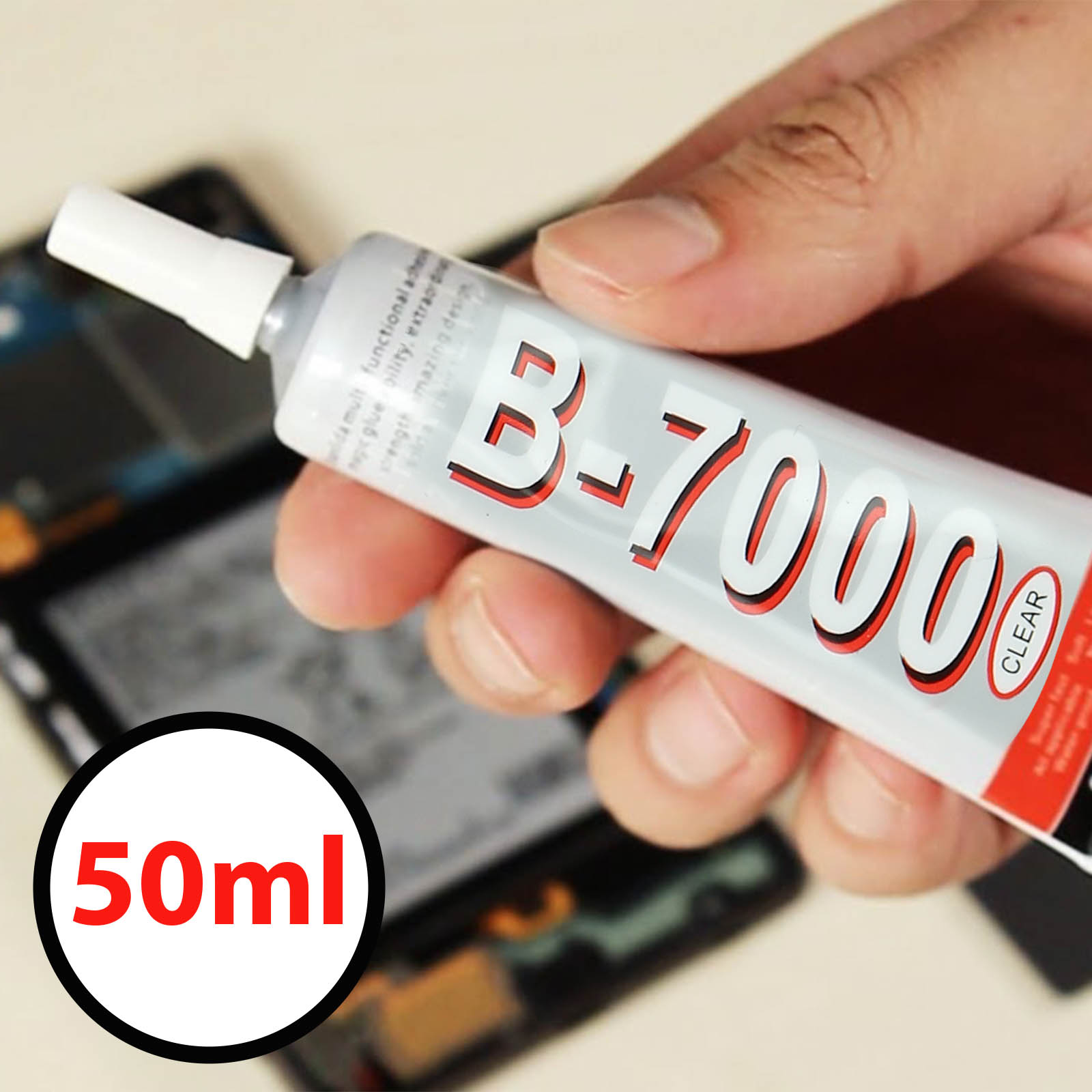 Mano tiene adesivo B-7000 con etichetta 50ml sopra uno smartphone smontato.