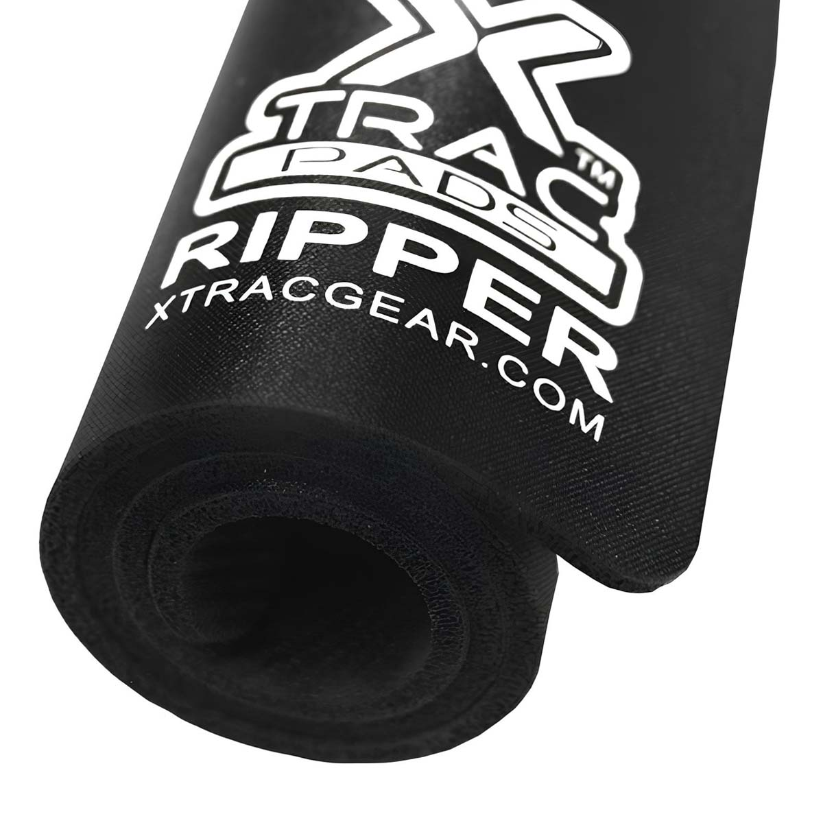 Tappetino nero con scritte bianche, arrotolato. "TRAC PADS RIPPER xtracgear.com"