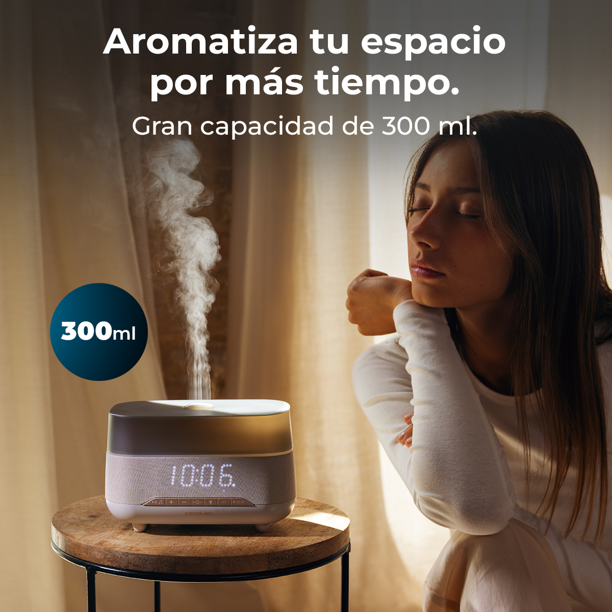 Un diffusore emette vapore, accanto a una donna seduta su un tavolo.