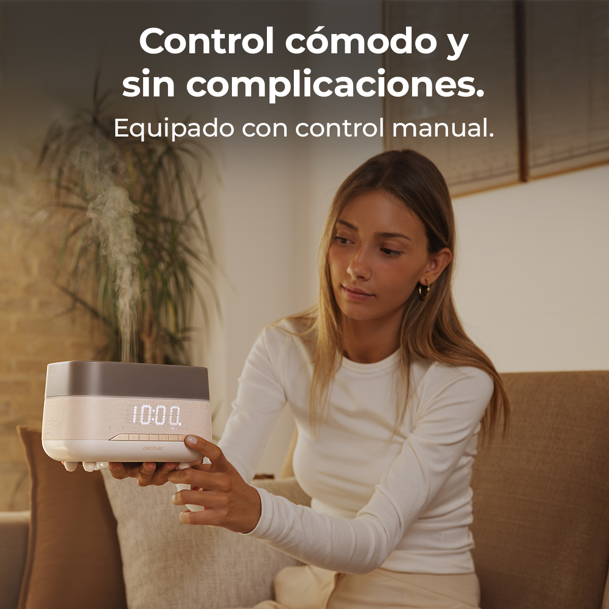 Una donna tiene un umidificatore con display digitale dell'ora in un soggiorno.