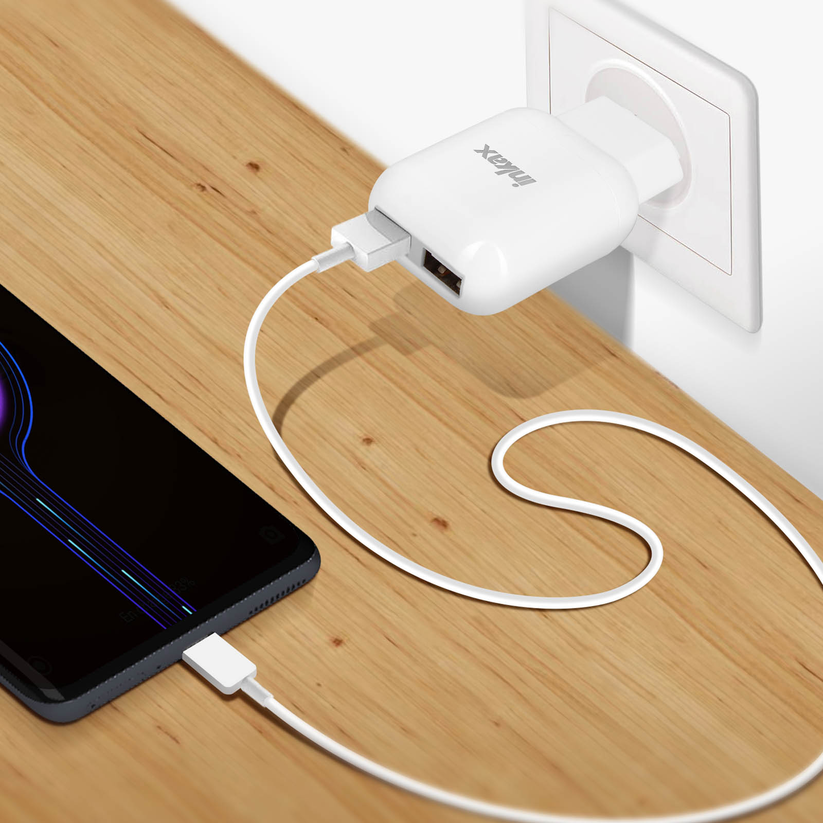 Un caricatore bianco con due porte USB è collegato a una presa a muro.
