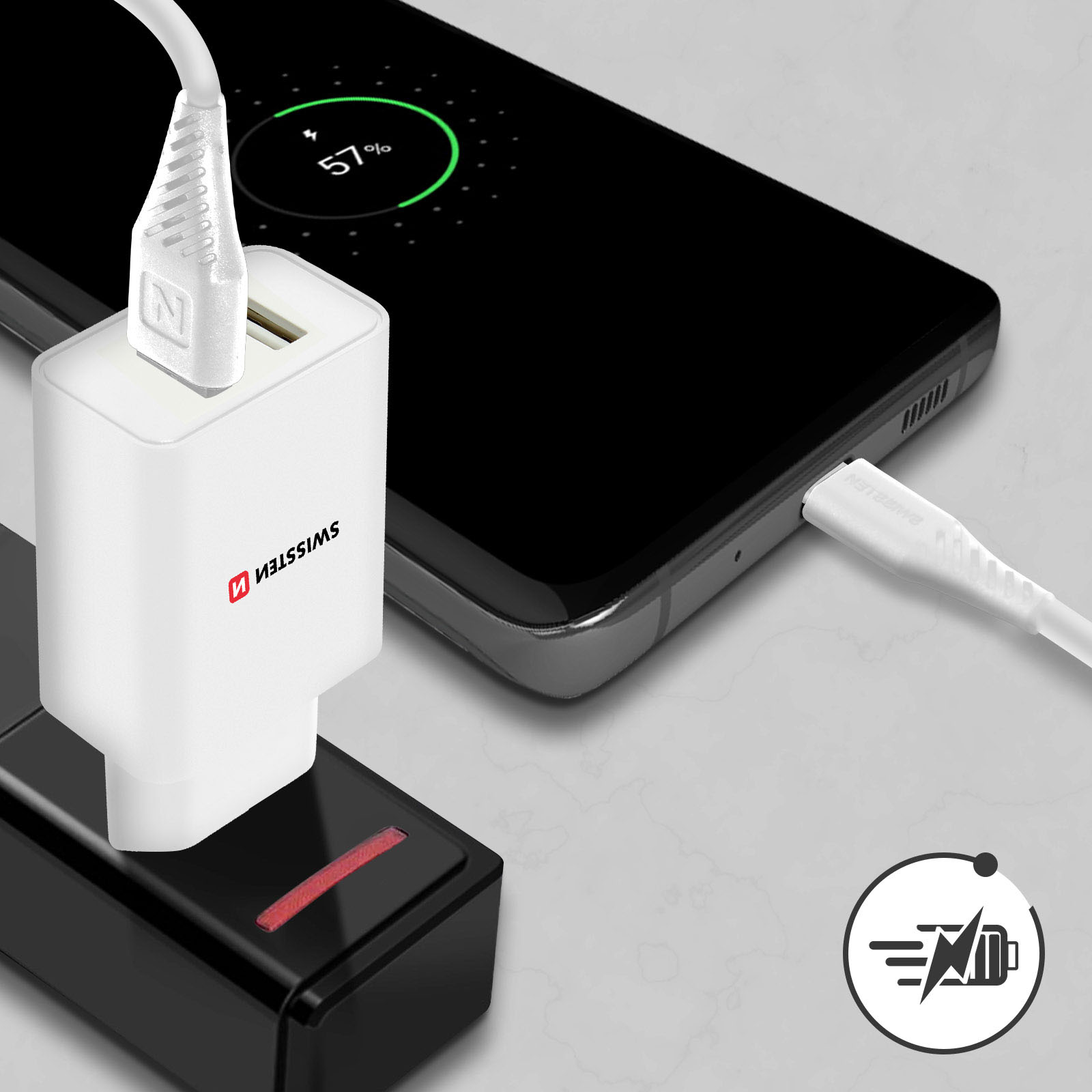 Un caricabatterie bianco è collegato a una presa, accanto c'è un cellulare.