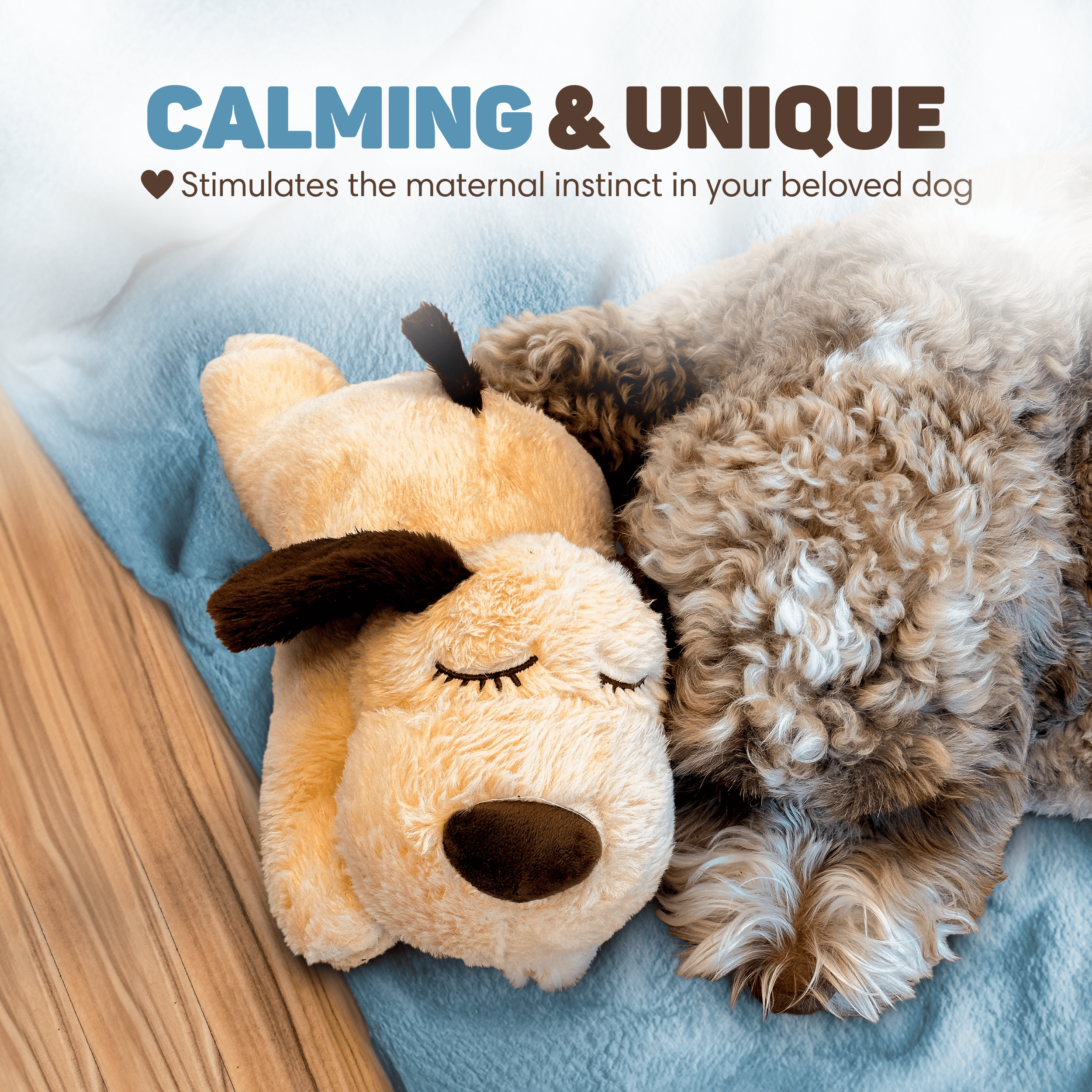 A dog sleeps next to a plush toy dog on a blue blanket.