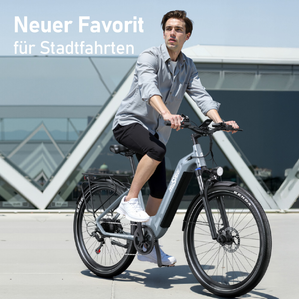 Ein Mann fährt ein silbernes E-Bike vor einem modernen Gebäude.