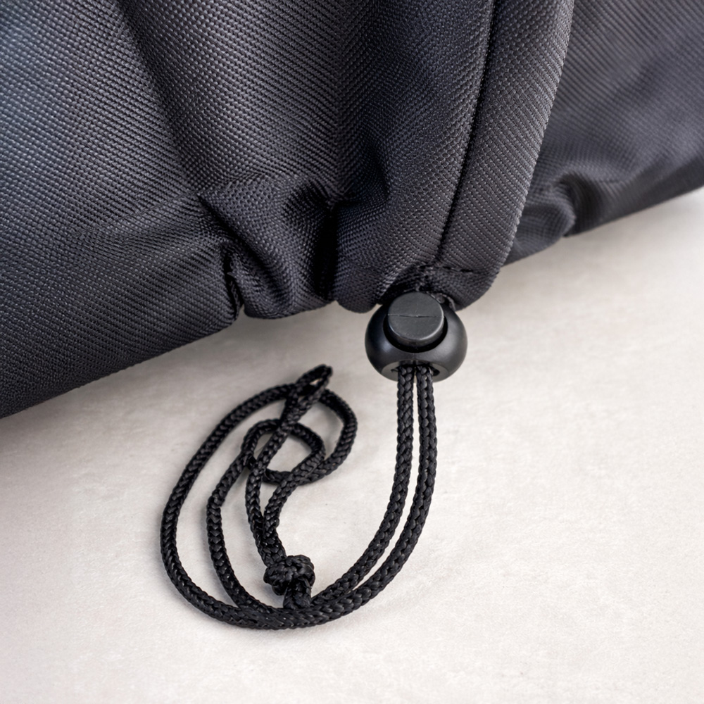 Black drawstring with a stopper on black fabric.