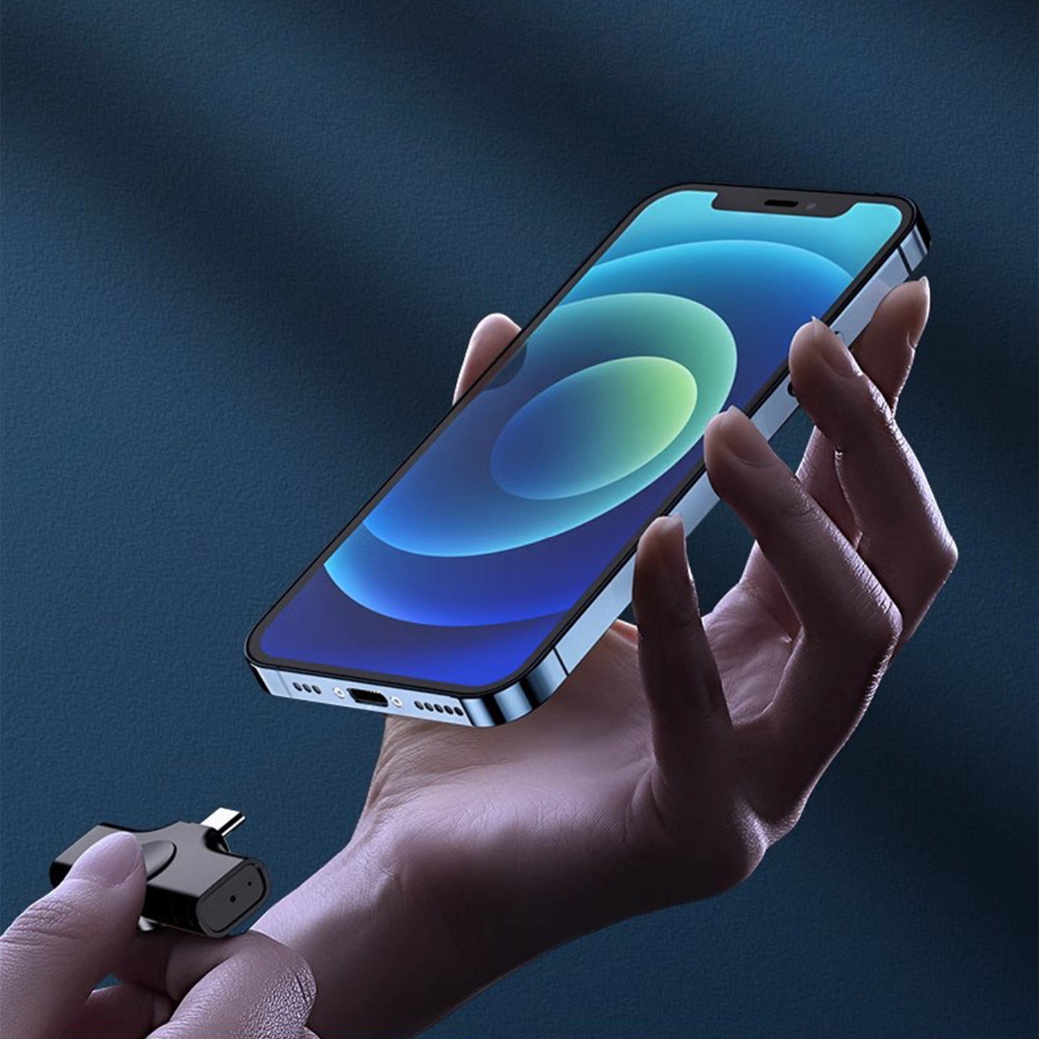 Dłoń trzyma smartfon, podczas gdy druga dłoń trzyma czarny dodatek.