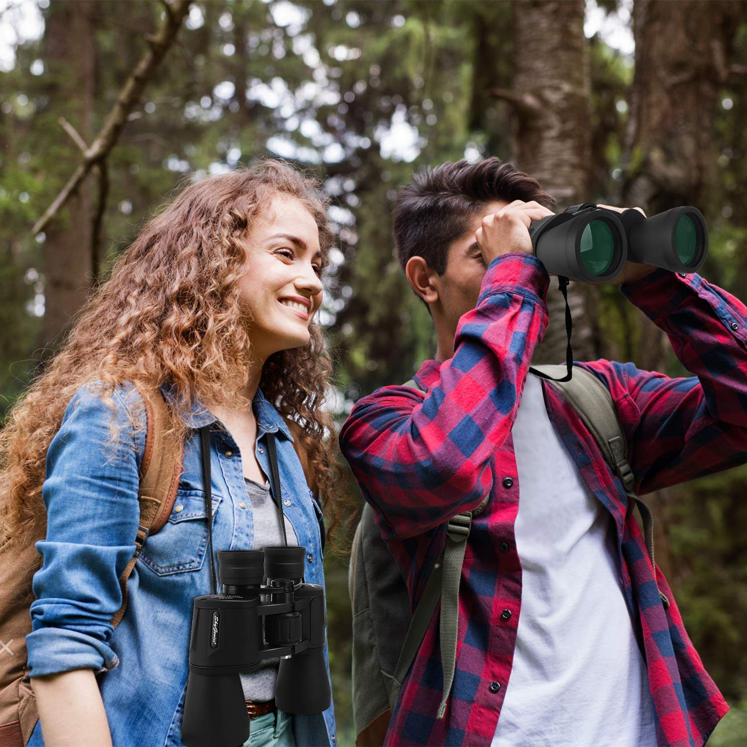Hombre y mujer con binoculares en el bosque, hombre mirando por binoculares.