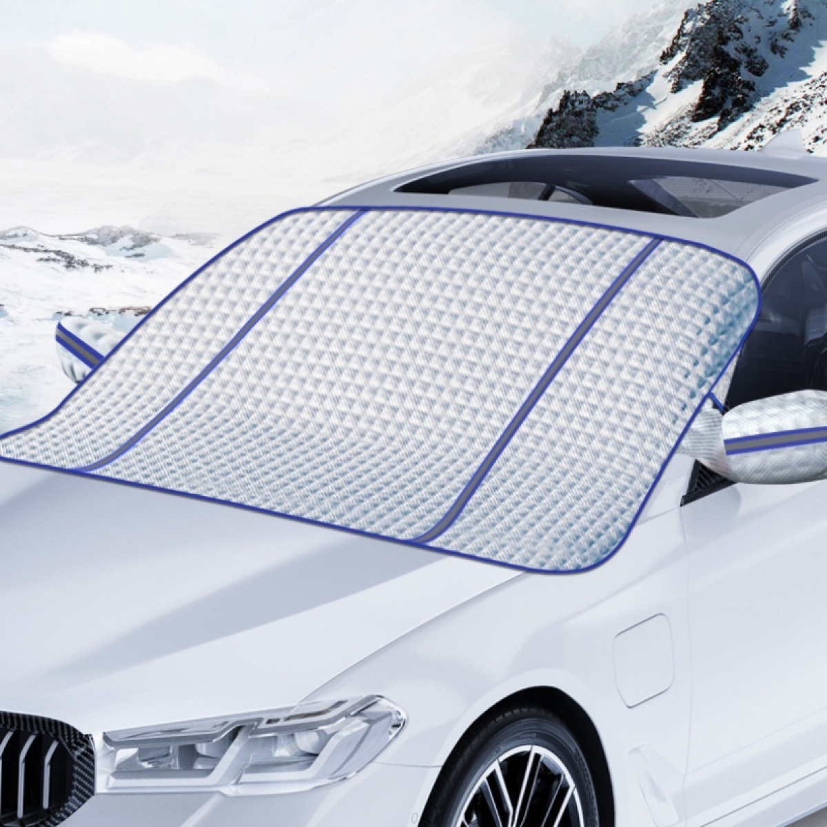 Weißes Auto mit Schneeschutzabdeckung auf der Windschutzscheibe im Winter.