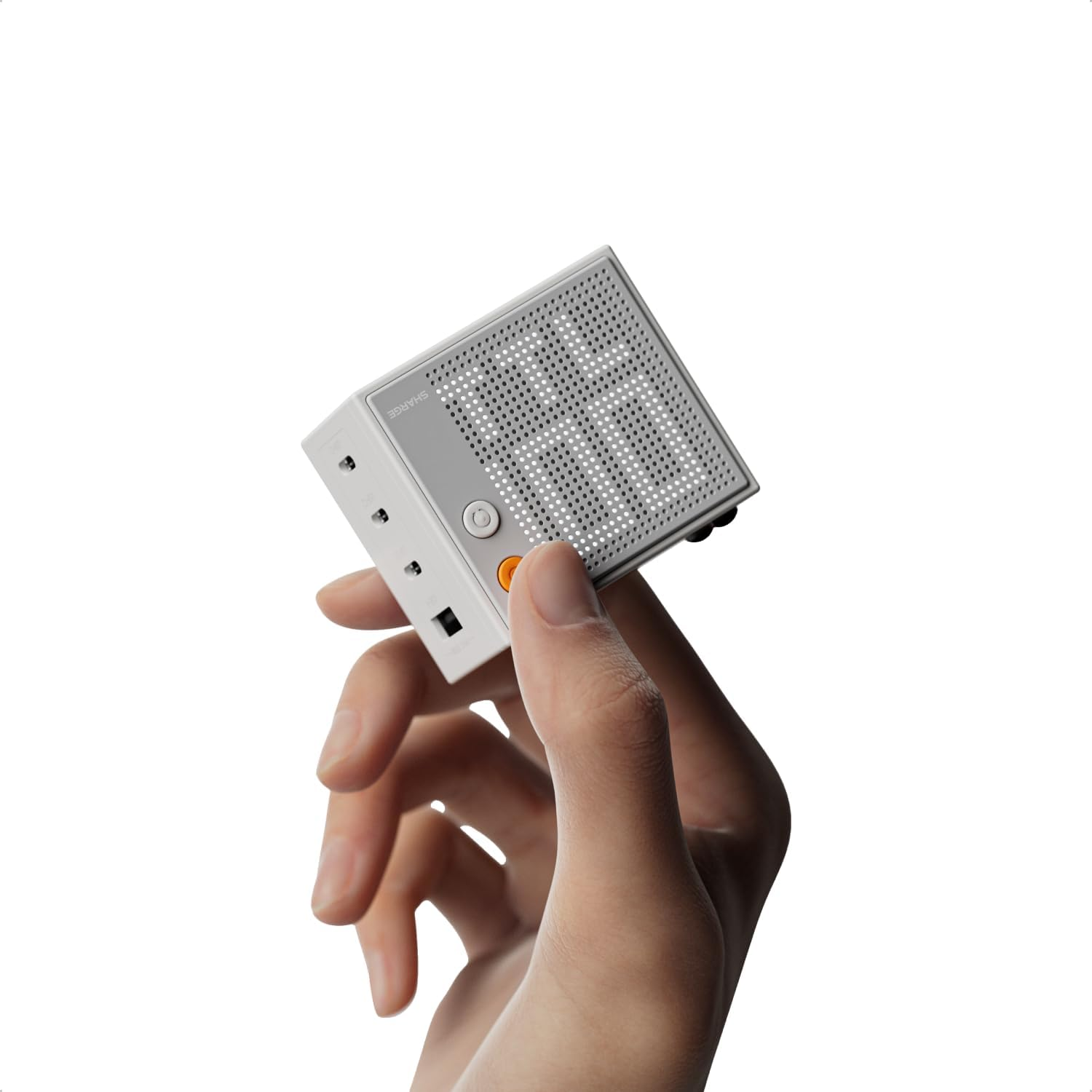 Mano tiene un altoparlante cubo bianco con pannello frontale grigio traforato.