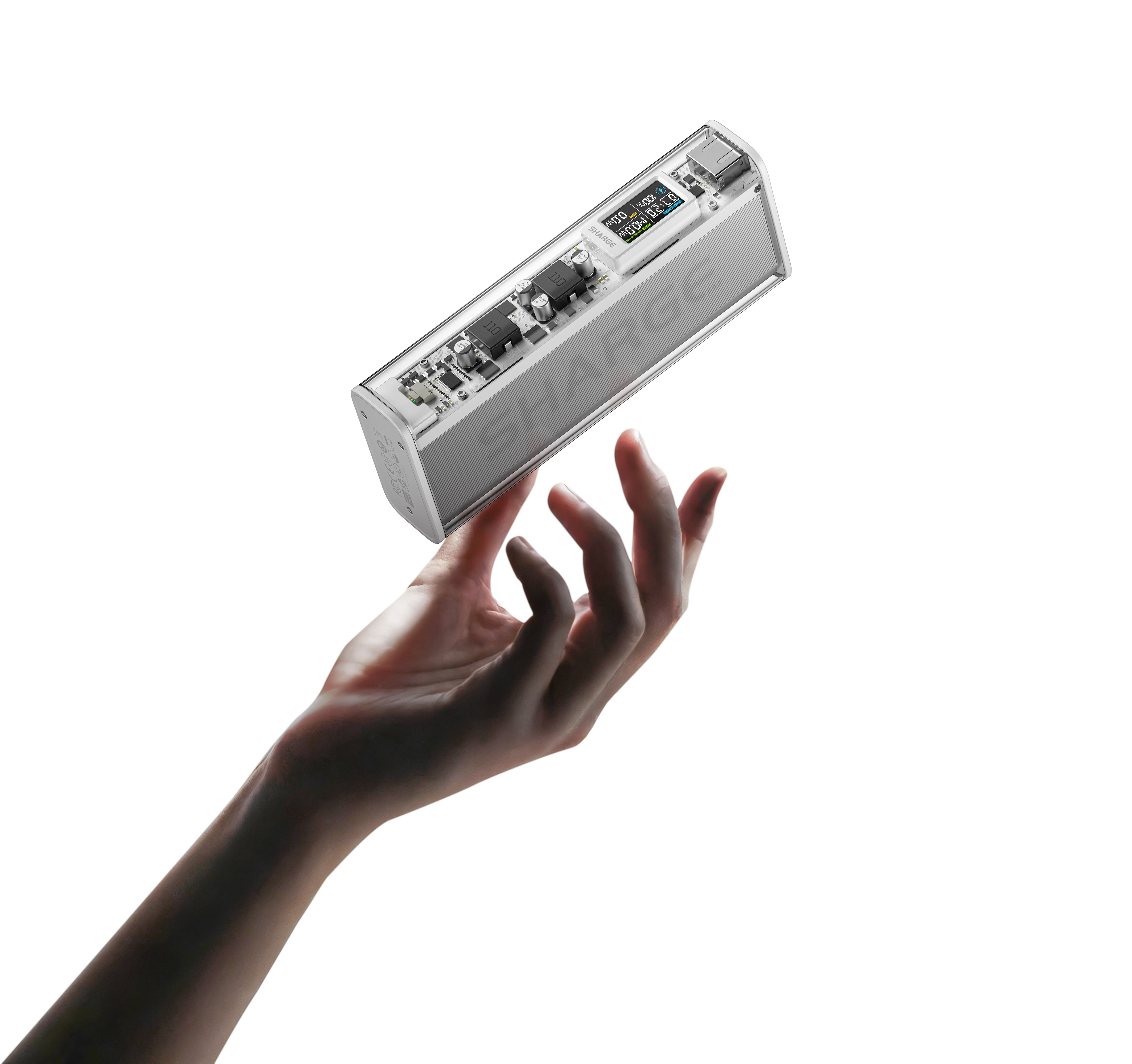 Une main tient une batterie externe transparente avec écran numérique sur fond blanc.