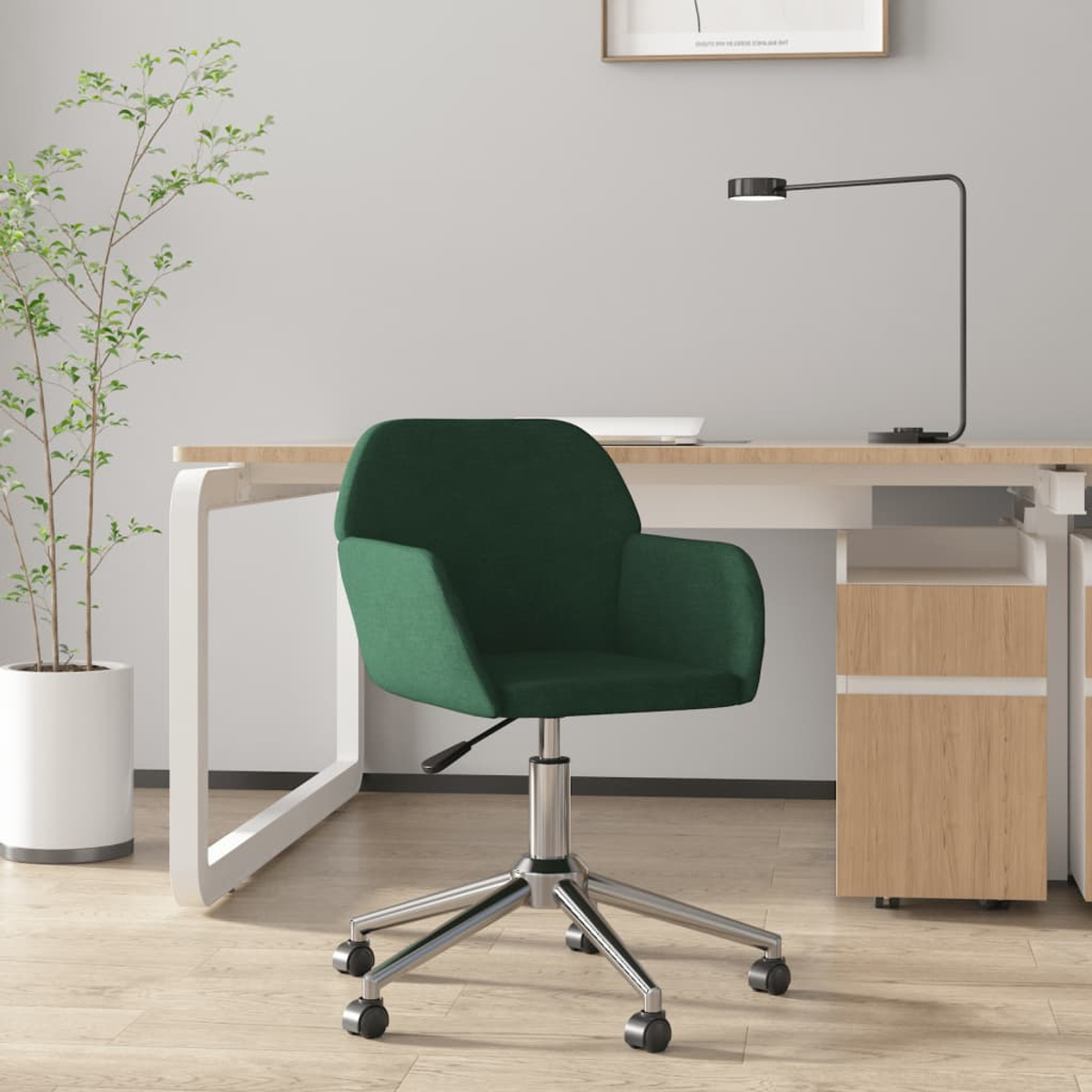 Ein grüner Bürostuhl mit Rollen steht vor einem Schreibtisch mit einer Lampe.