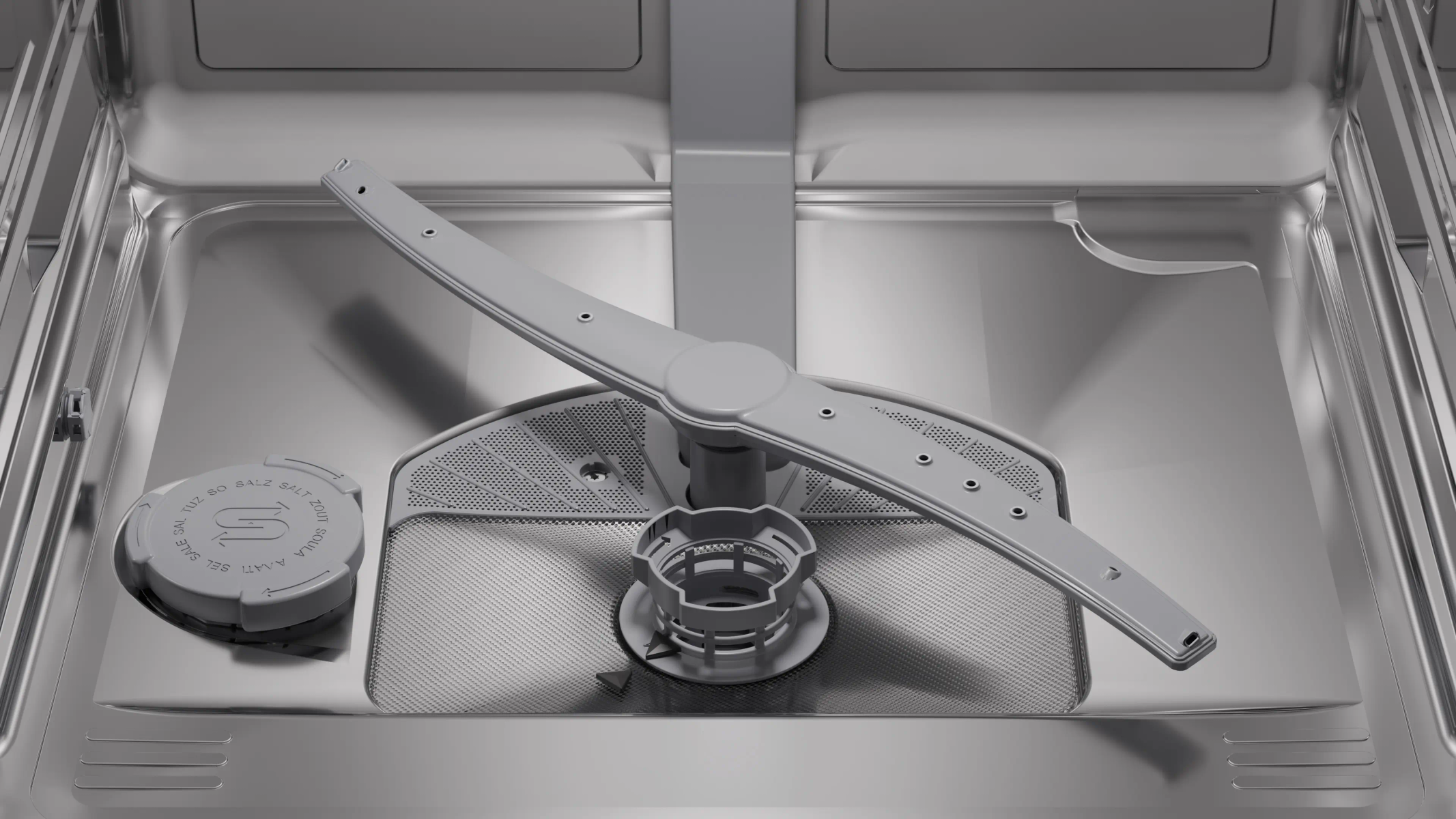 Interior of a dishwasher with spray arm and salt compartment.