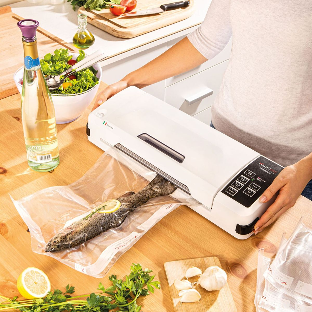 Osoba używa zgrzewarki próżniowej do zamykania ryby w plastikowej torbie.