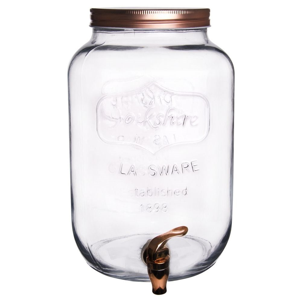 Un dispensador de vidrio transparente con tapa y grifo de cobre.