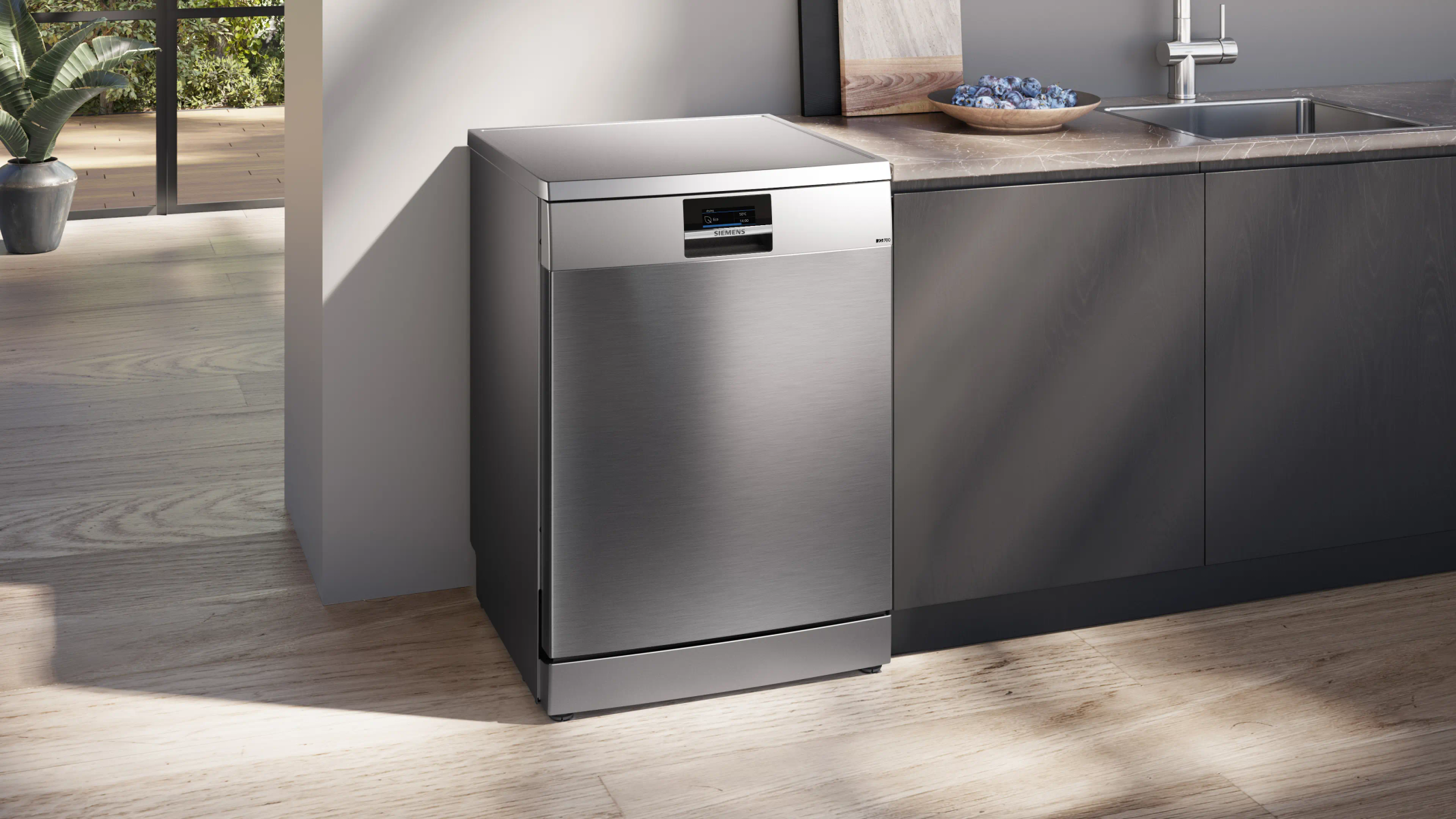 Lavavajillas moderno de acero inoxidable junto a una encimera de cocina con fregadero.