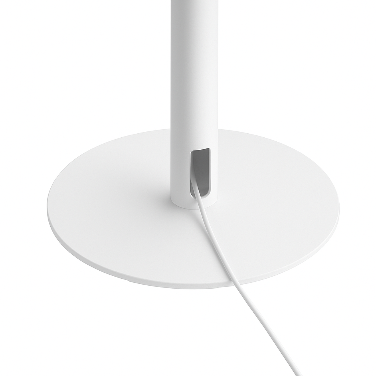 Ein weißes Kabel führt aus einer rechteckigen Öffnung am Sockel einer weißen Stehleuchte.