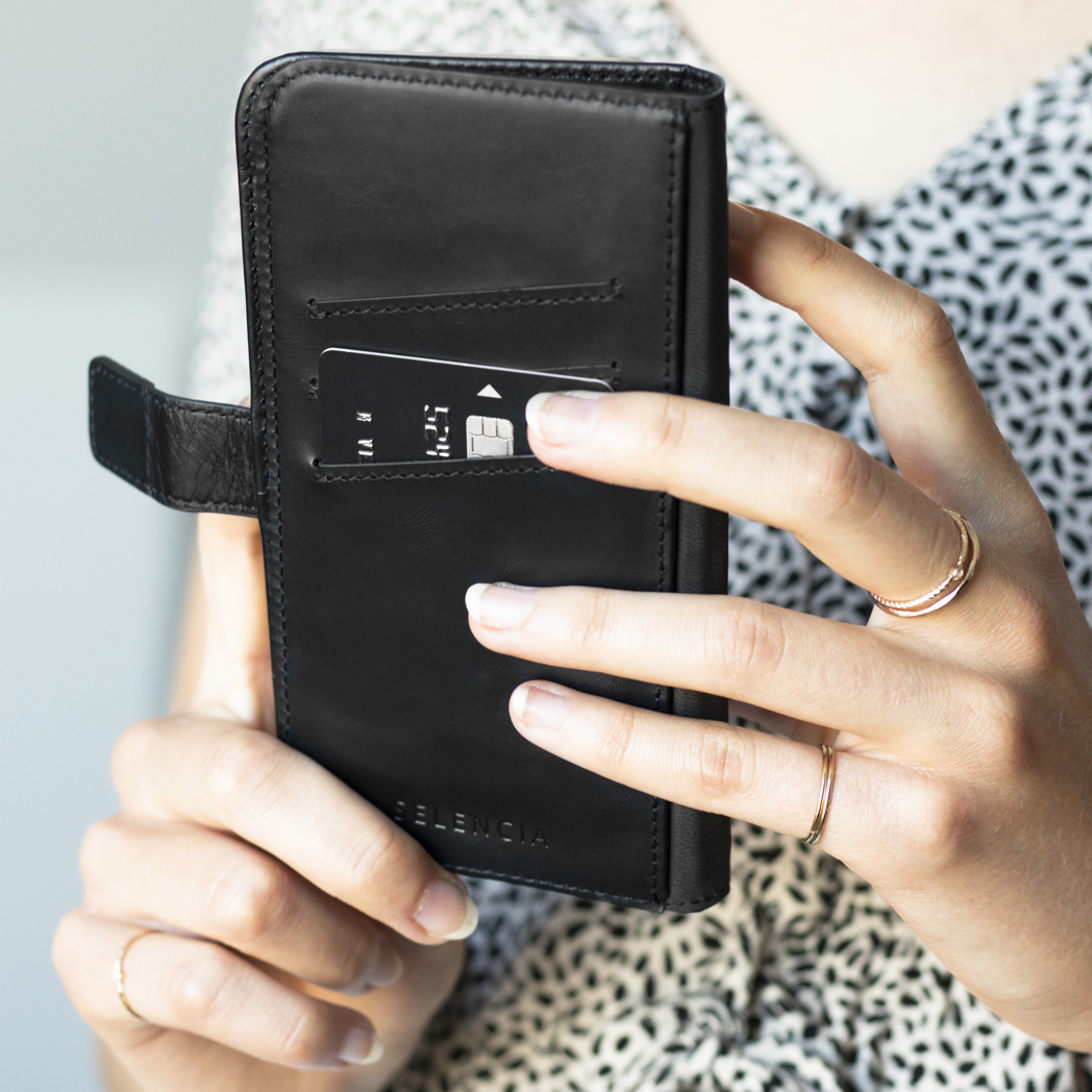 Una persona tiene un portafoglio nero con una carta di credito.