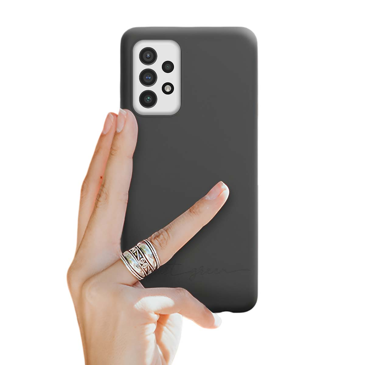 Una mano con anelli tiene una cover scura per telefono con layout fotocamera.