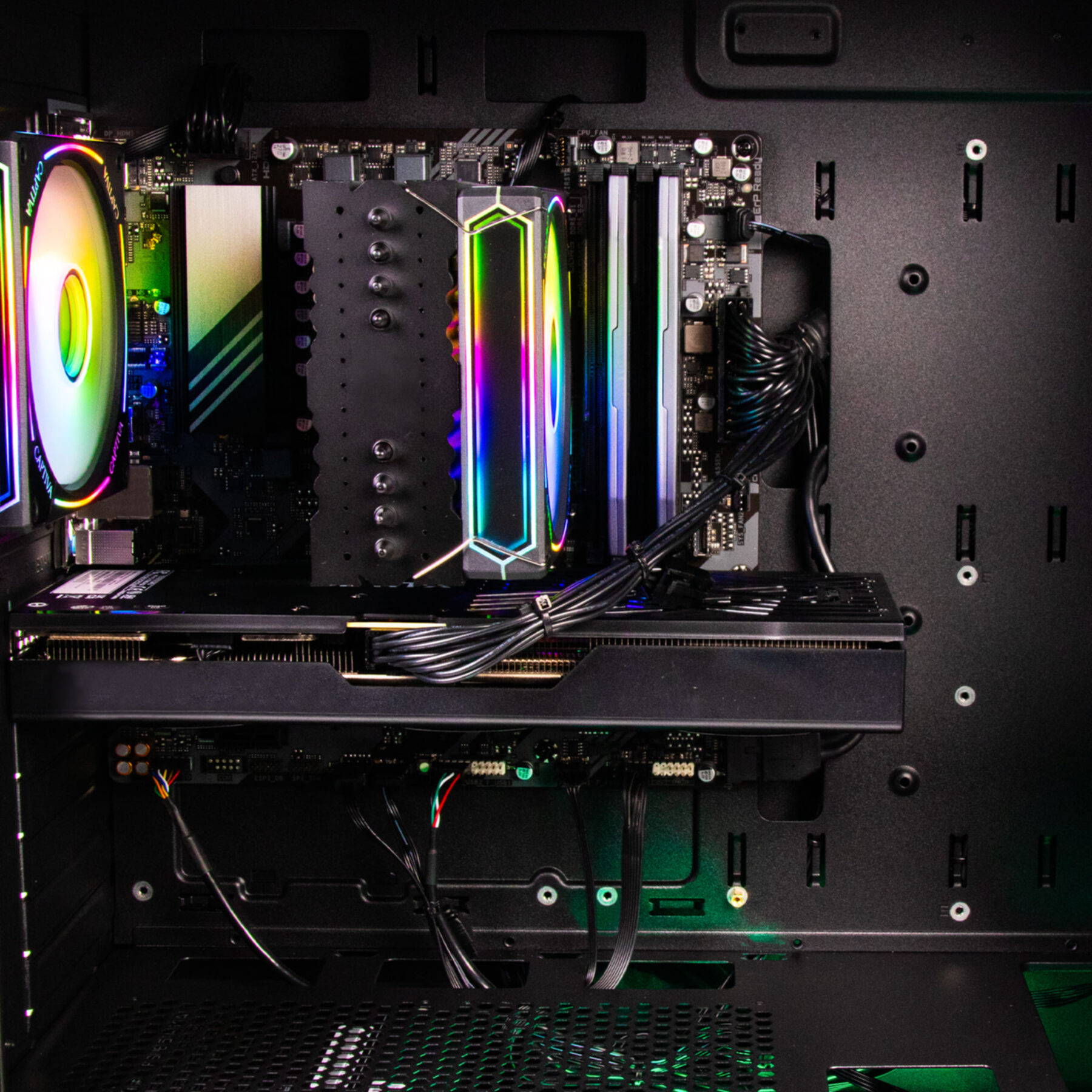 Interno case PC con dissipatore CPU, RAM, GPU e cavi. Illuminazione RGB visibile.