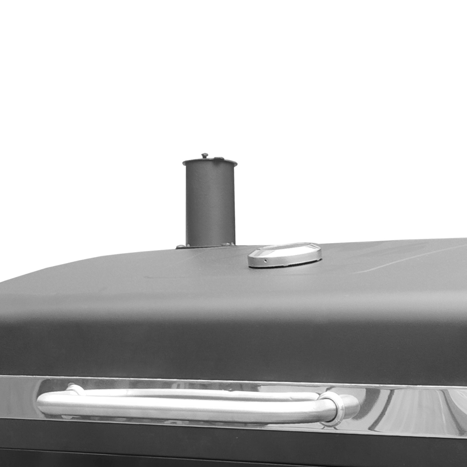 Zbliżenie czarnej pokrywy grilla ze srebrną rączką i kominem.