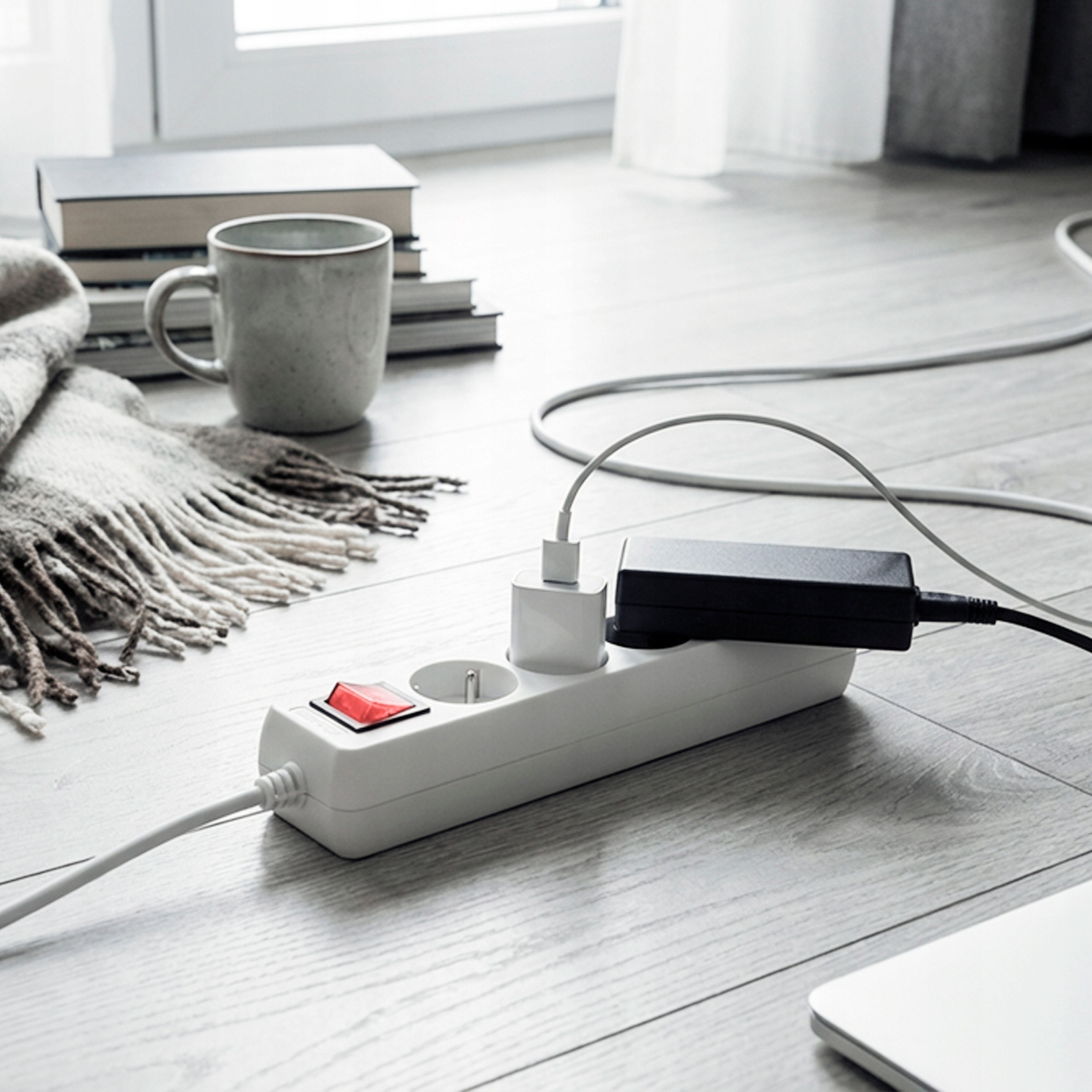 Biała listwa zasilająca z czerwonym włącznikiem, kablem i adapterem.