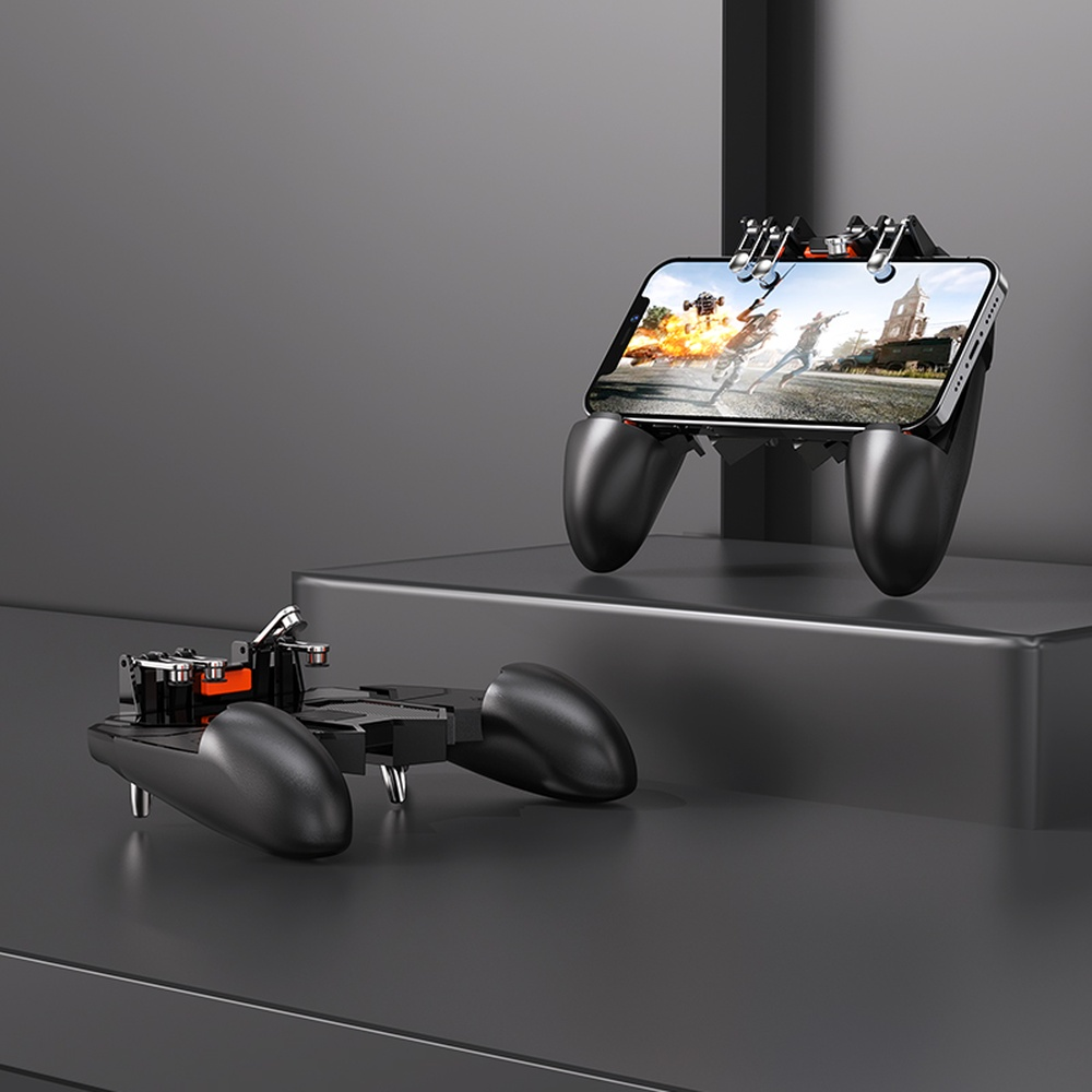 Dos mandos negros para juegos móviles en superficies oscuras. Uno está en uso, sujetando un teléfono que muestra un juego.