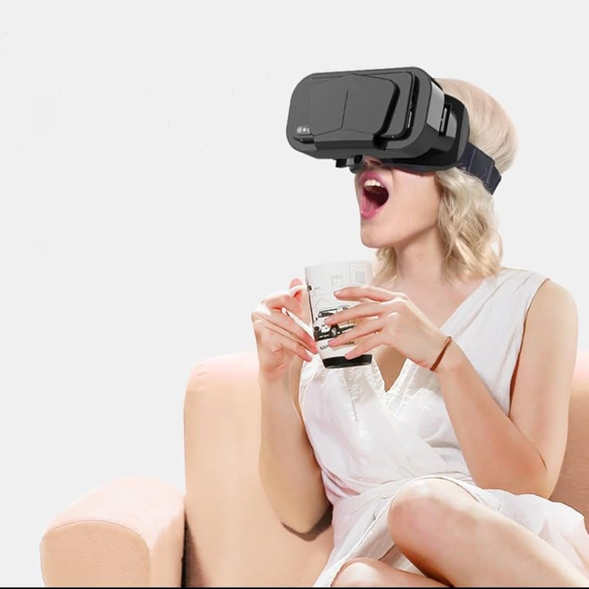 Eine Frau mit VR-Brille trinkt aus einer Tasse und sitzt auf einem Sofa.